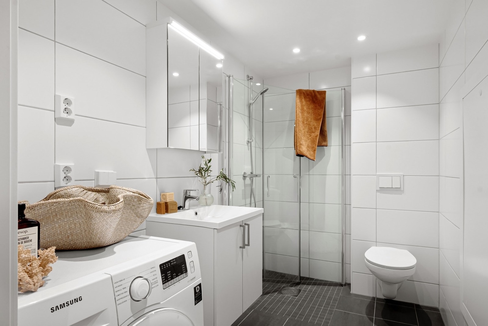 Badet fremstår lyst og moderne, med flislagte gulv og vegger, behagelig gulvvarme og downlights i taket. Galleribilde