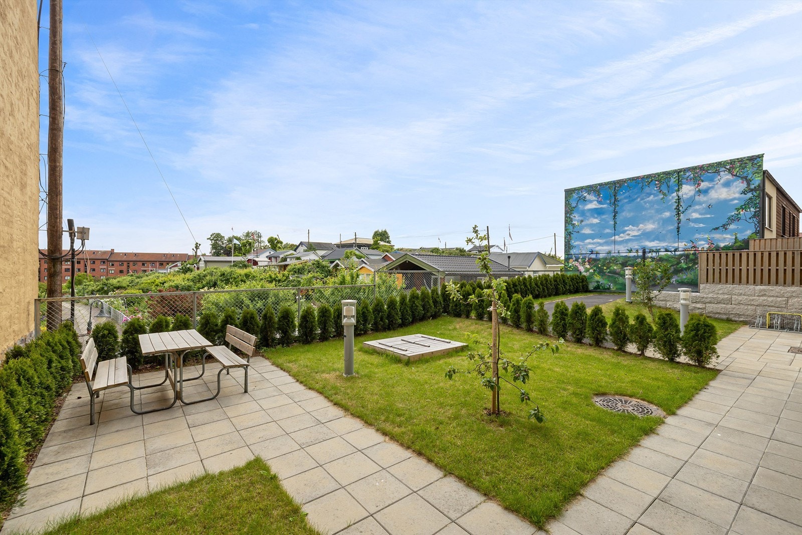 Pent opparbeidet fellesareal med sitteplasser, sykkelparkering og beplanting. Galleribilde