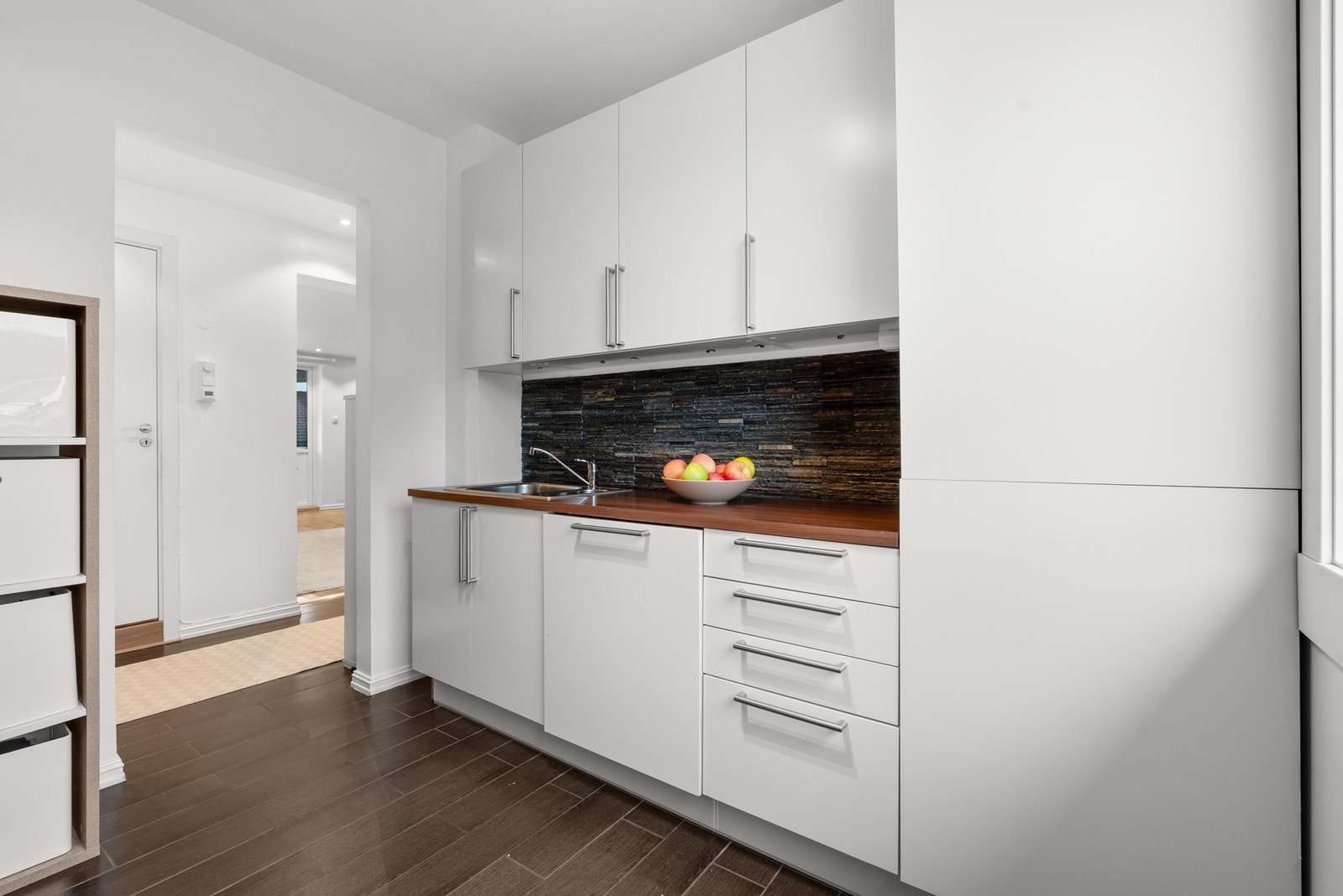 Glatte, folierte fronter og en laminat benkeplate med nedfelt kum i rustfritt stål. Galleribilde