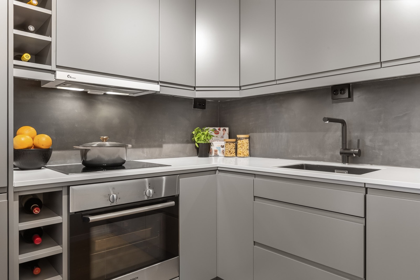 Kjøkkenet har en moderne innredning med slette fronter og benkeplate i stein. Galleribilde