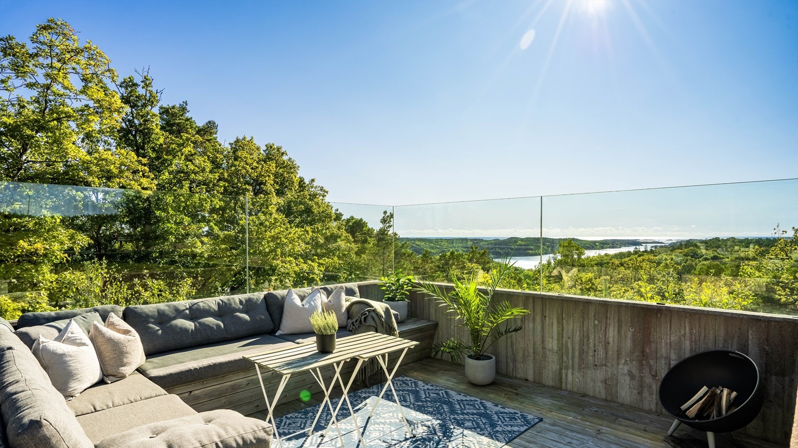 Store deler av tomten ut mot skogen er innrammet med rekkverk i glass Galleribilde