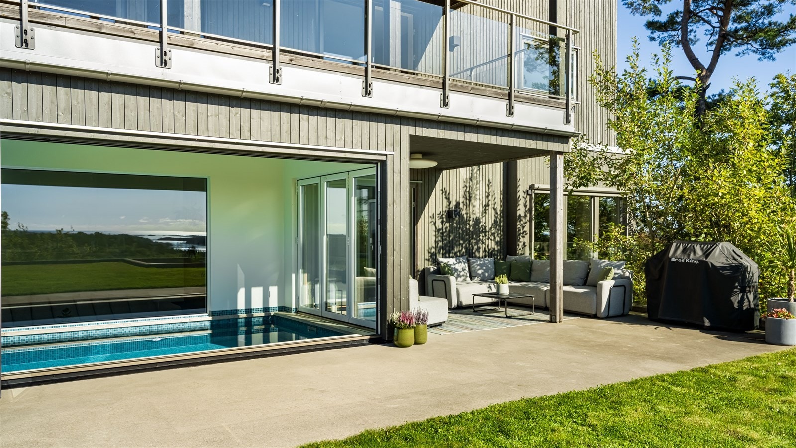 Utearealet blades flott sammen med bassenget når man har foldedørene åpne Galleribilde