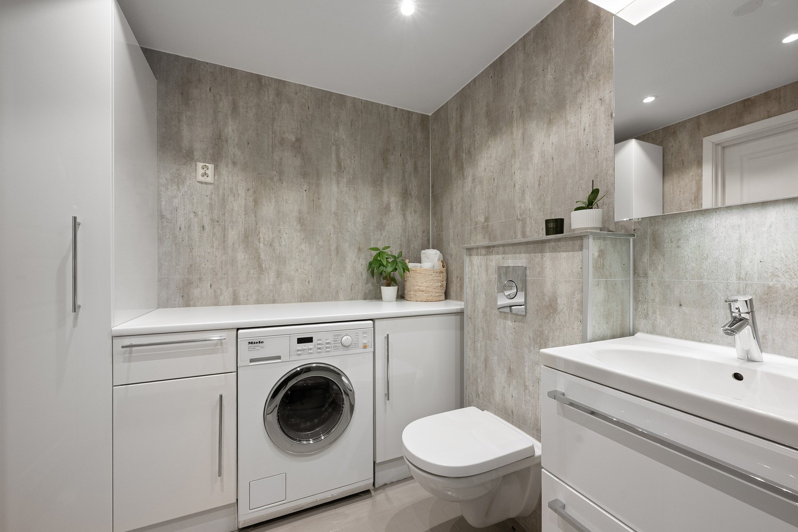 Delikat bad med downlights i himling og praktisk vaskeromsinnredning med god oppbevaringsplass og arbeidsbenk. Det er opplegg for vaskemaskin, og denne kan medfølge etter nærmere avtale. Galleribilde