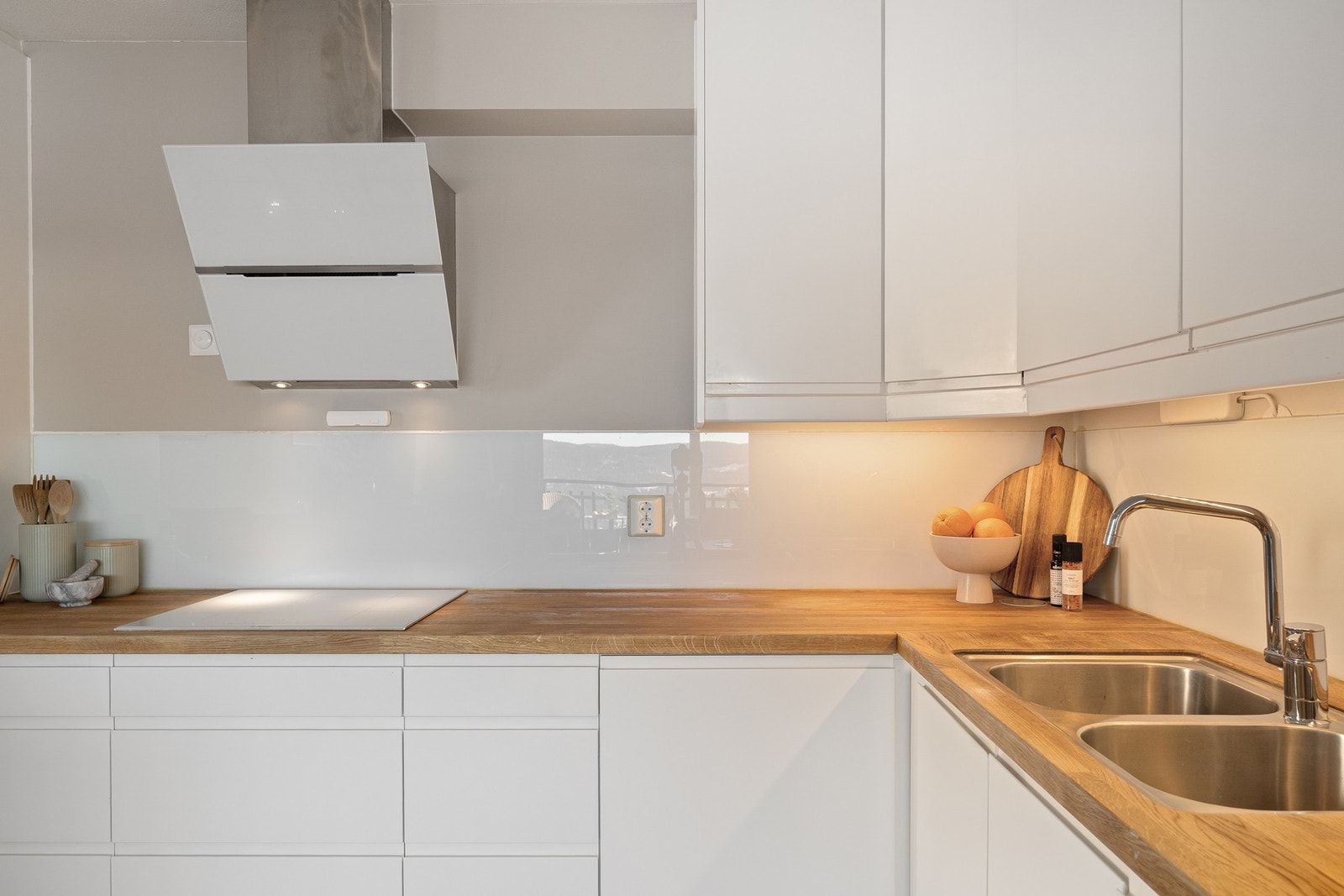 Praktisk underlimt oppvaskkum og glassplate over benkeplaten som beskytter veggen. Godt med stikkontakter og benkebelysning. Galleribilde