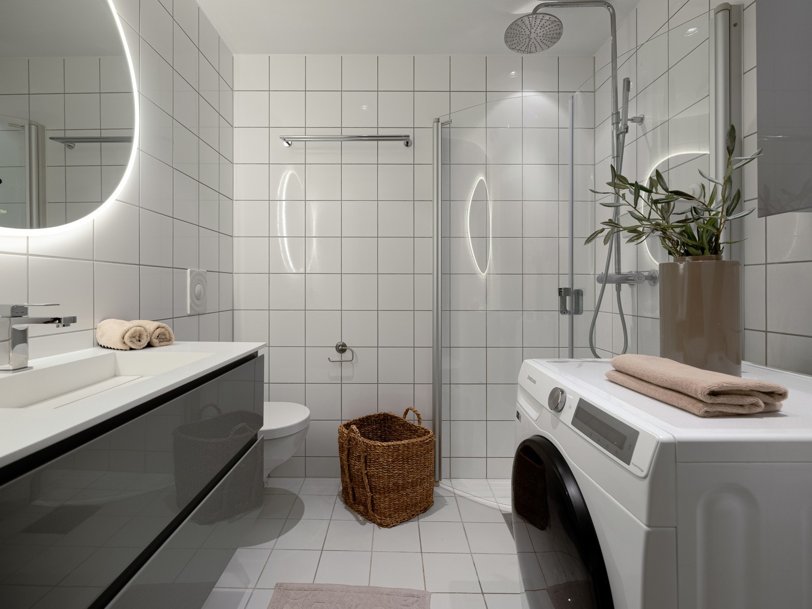 Boligen har et lekkert flislagt bad med stilren baderommsinnredning med servantskuffer. Galleribilde