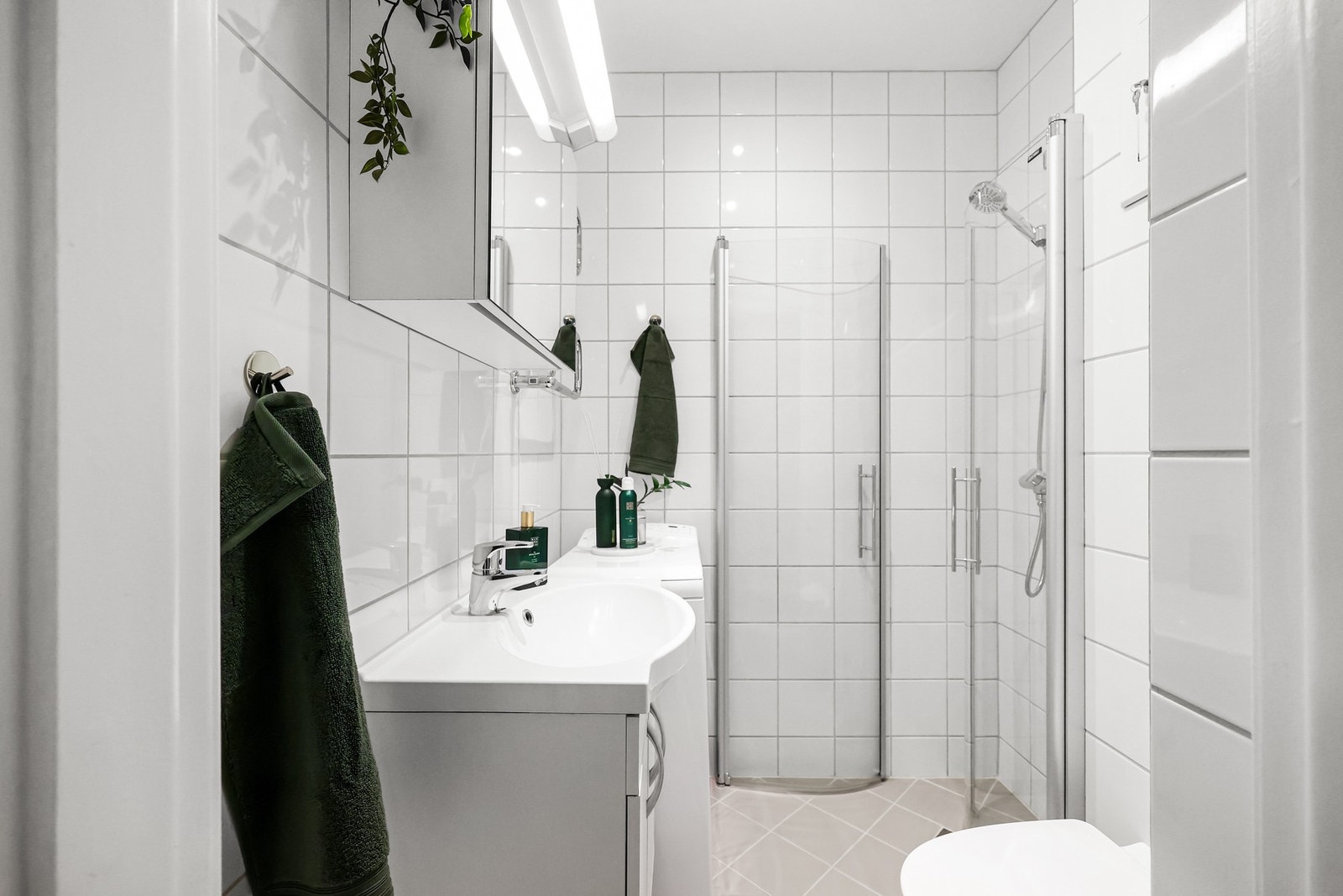 Flislagt bad innredet med dusjnisje med svingbare dusjvegger og termostatstyrt dusjbatteri i krom med hånddusj. Galleribilde