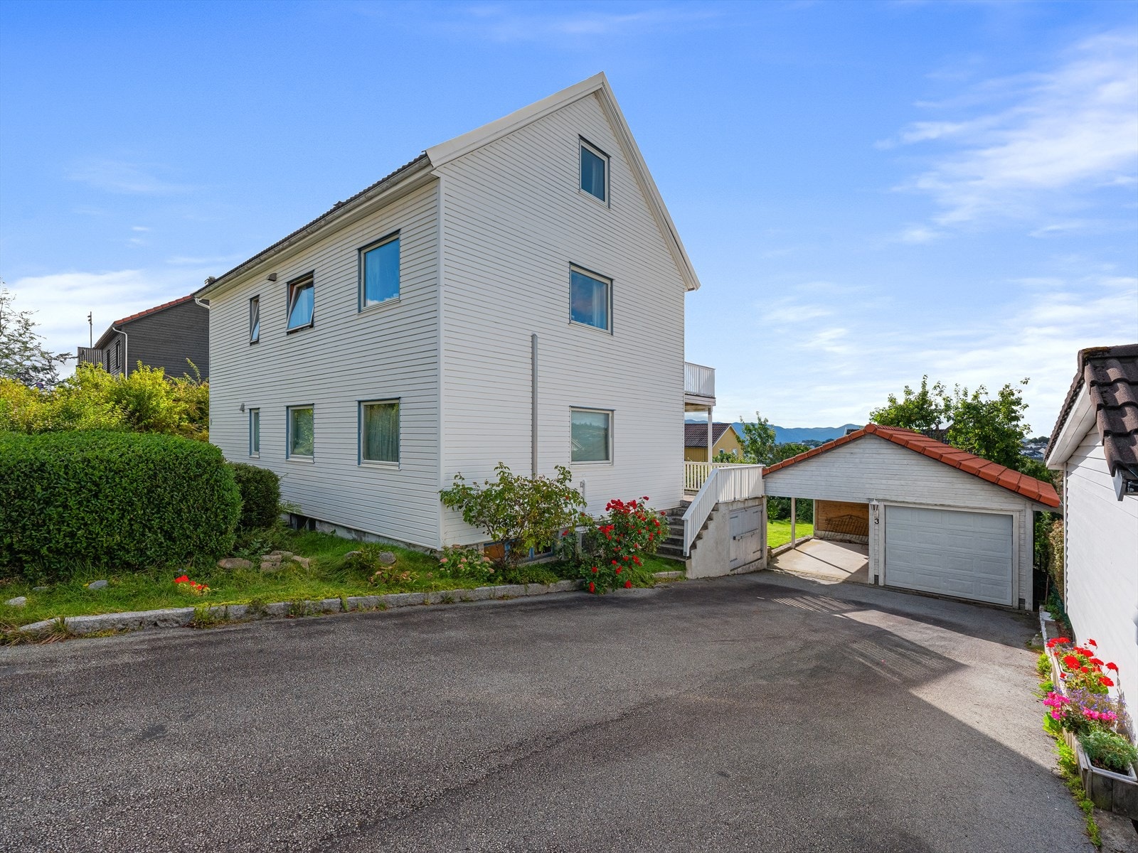 Eiendommen inneholder dobbel garasje med en lukket del og en carport, samt god oppstillingsplass i gårdsrom for besøkende Galleribilde