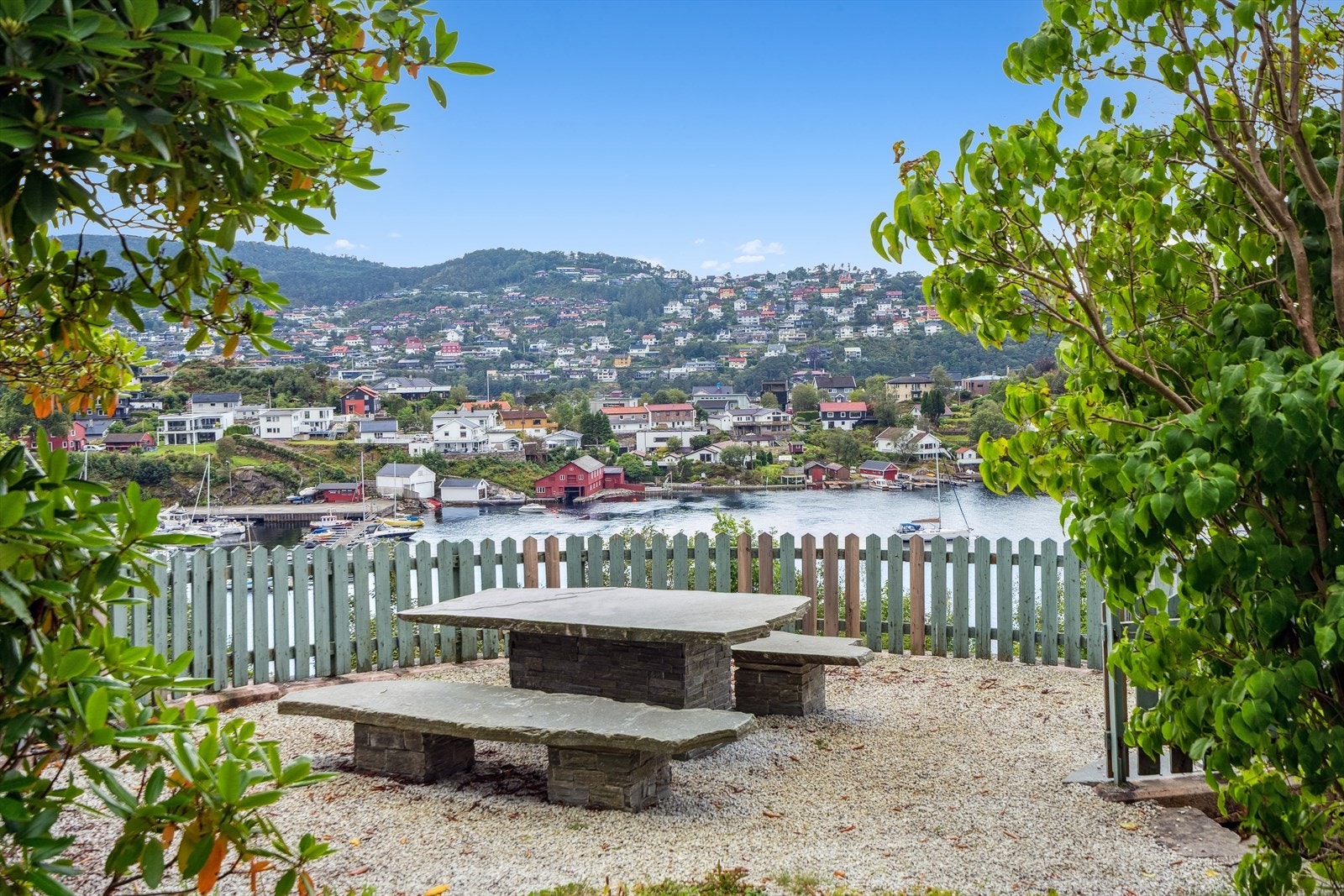 Koslig fellesområde med sittegrupper og sjøutsikt. Videre er det grøntområde med plen og bærbusker på borettslagets eiendom. Galleribilde