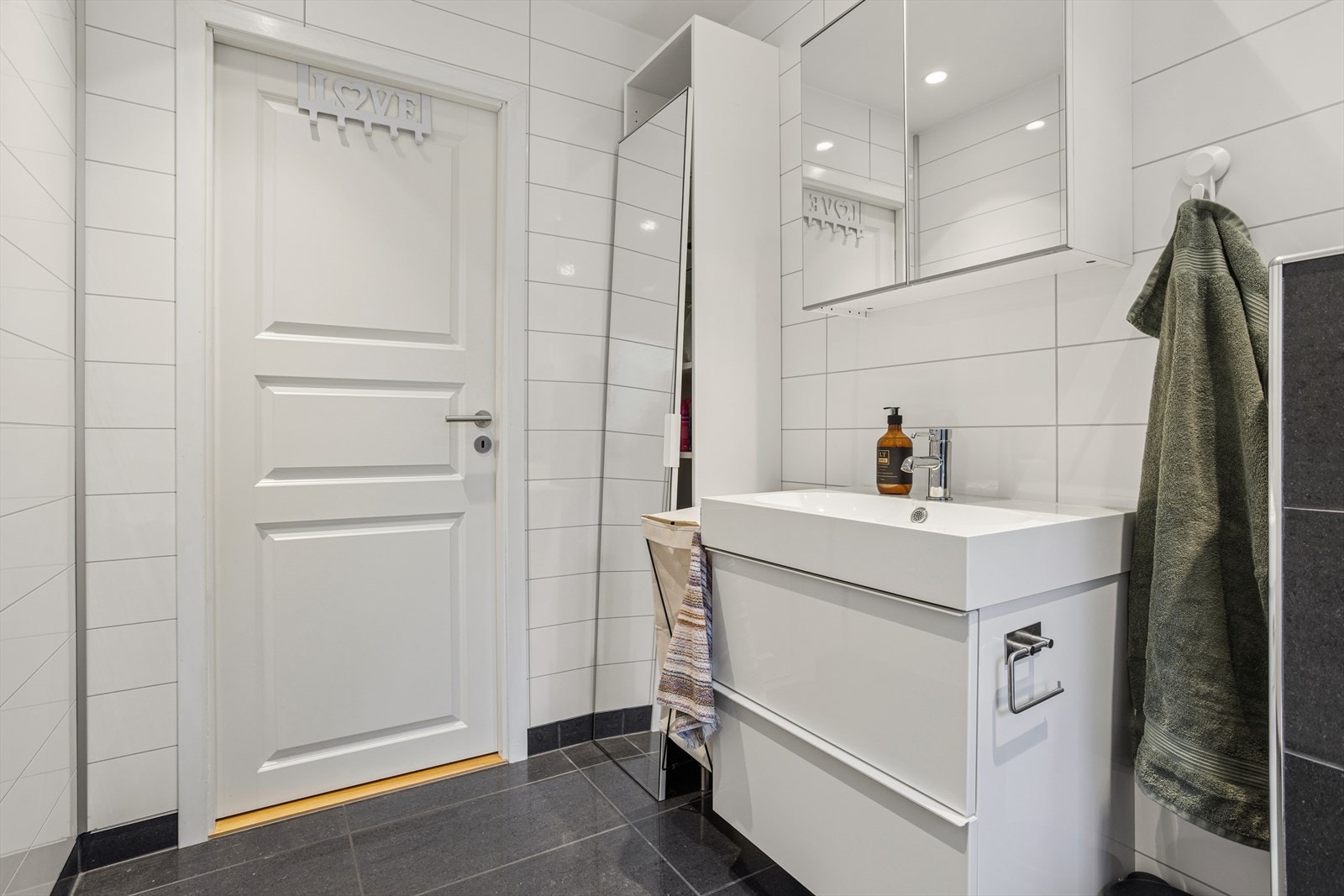 Praktisk innredning med romslig servantskap og speil med integrert belysning. Opplegg til vaskesøyle. Galleribilde