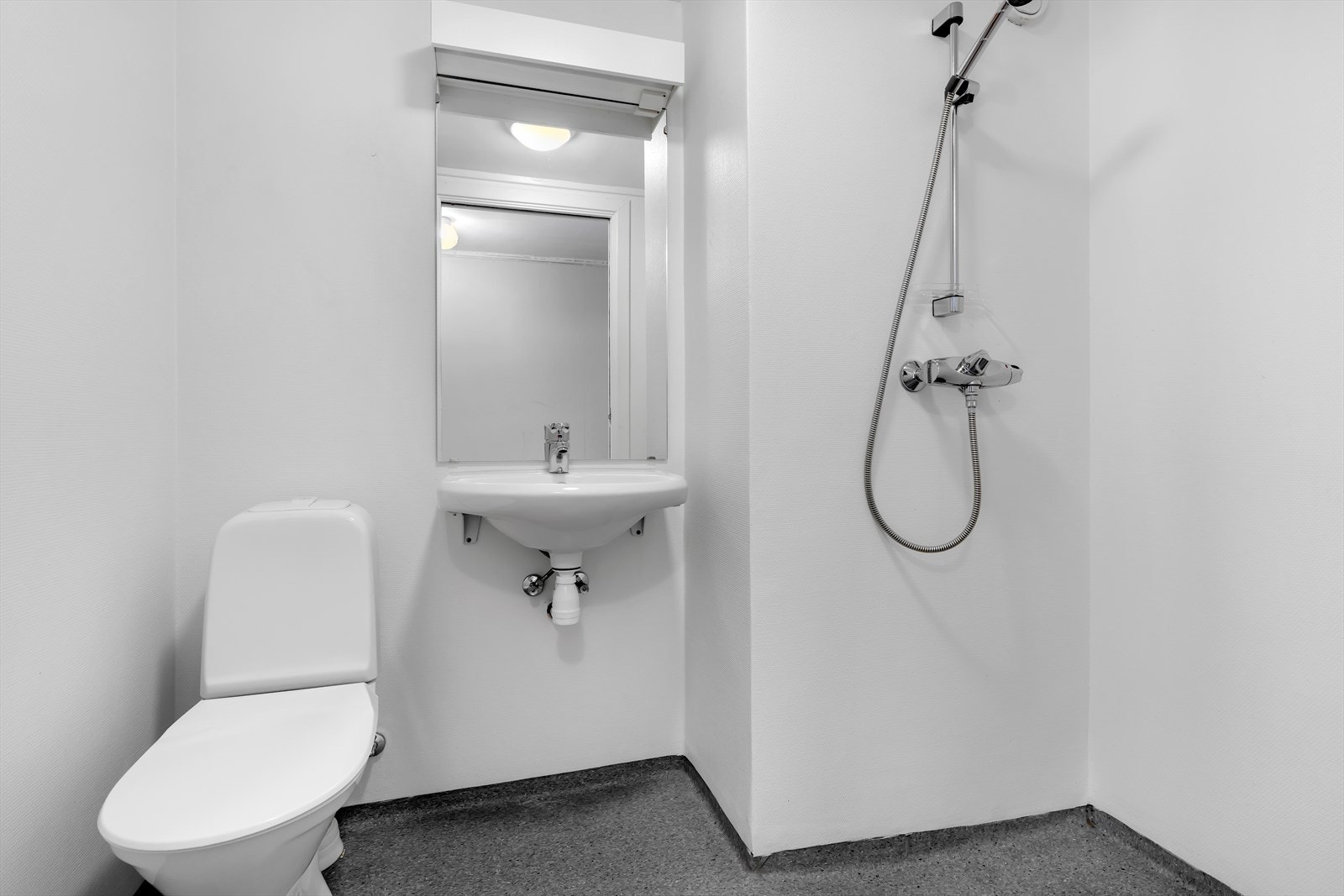 Enklere innredet med wc, porselensvask og åpen dusj Galleribilde