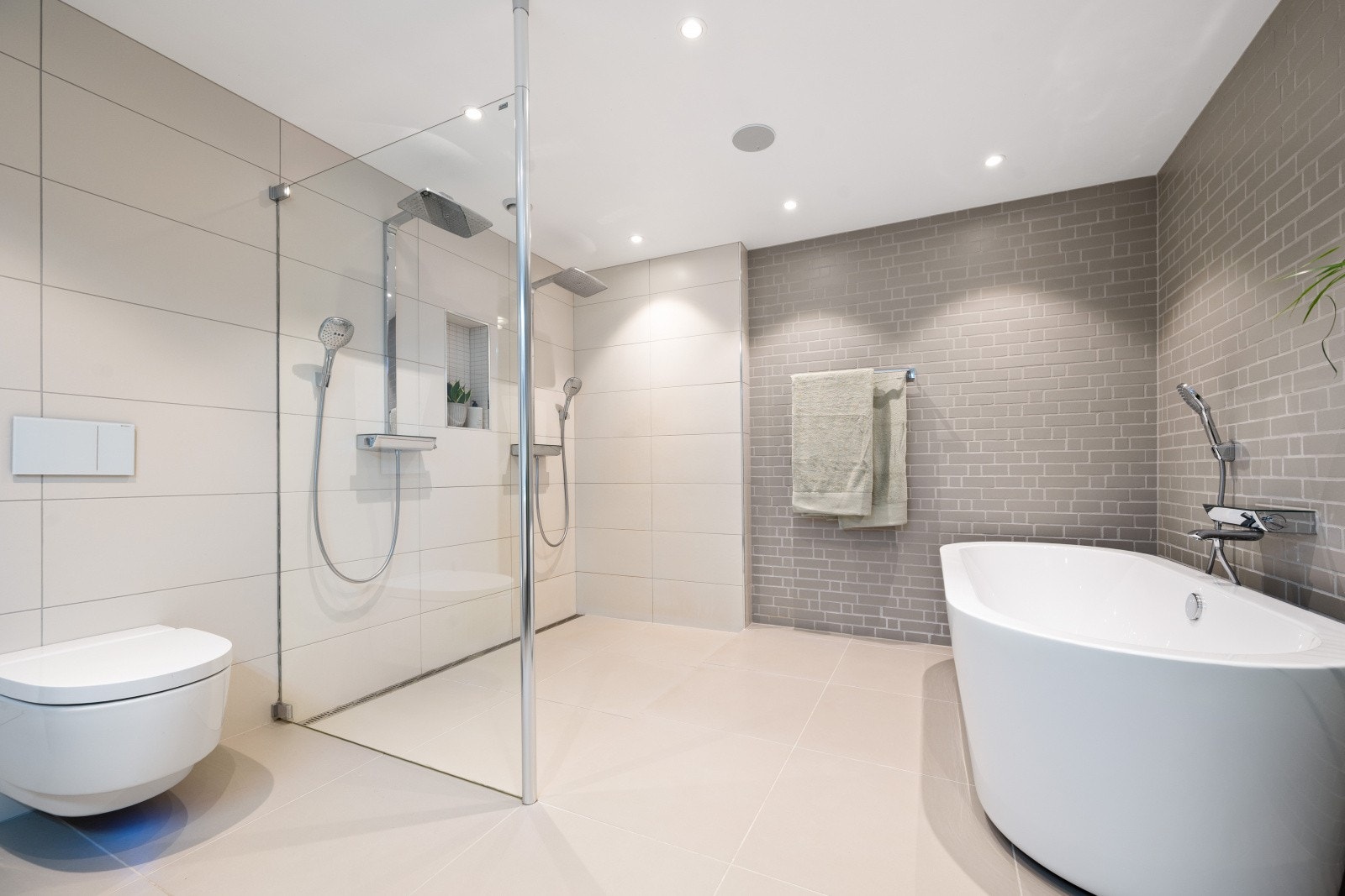 Her er det både frittstående badekar og en stor dusjsone med doble dusjer. Galleribilde