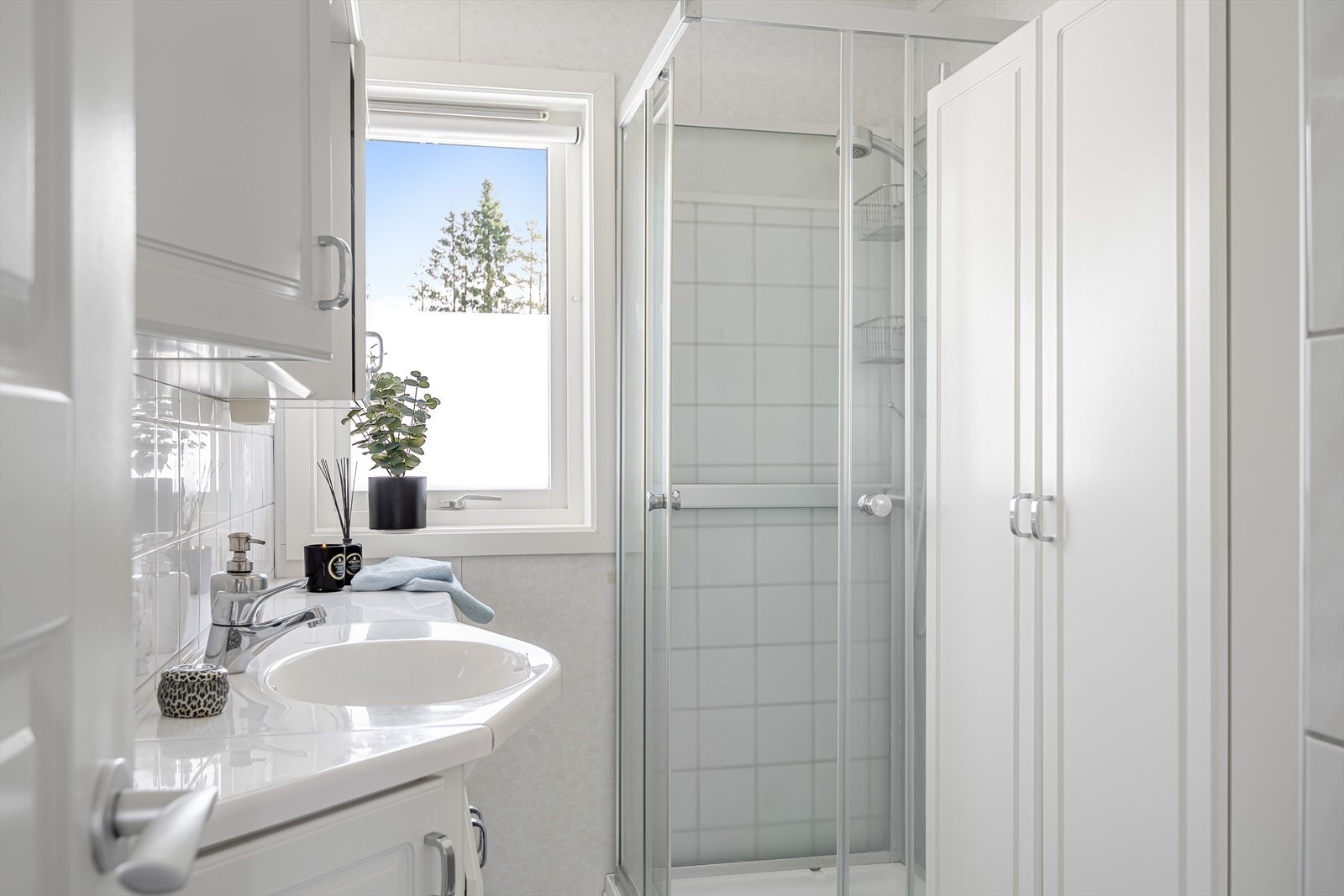 Boligen har et lyst baderom fra ukjent årstall. Baderommet har flislagt gulv og overflater med fliser kombinert med våtromsplater. Galleribilde