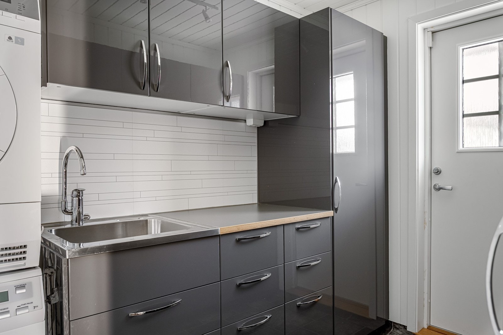 Vaskerommet har belegg på gulv, lyse panelplater på veggene og egen utgang. Galleribilde