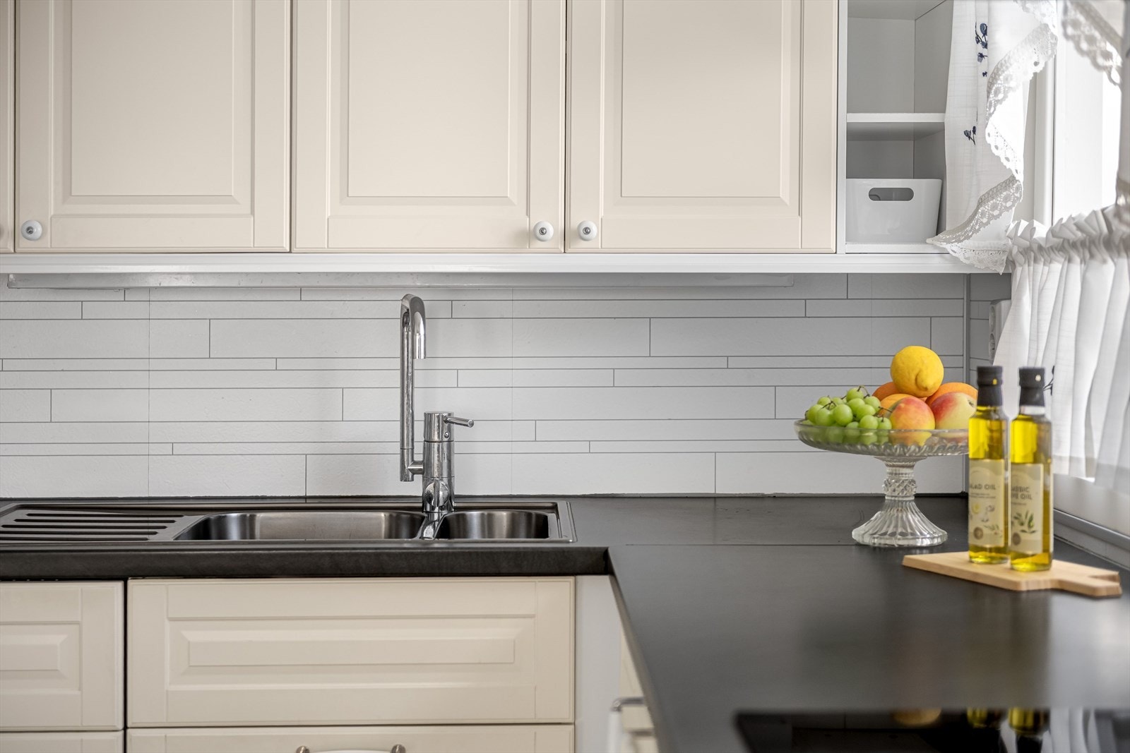 Praktisk med lyse flisimitasjonsplater i benkeryggen og belysning under overskapene. Galleribilde