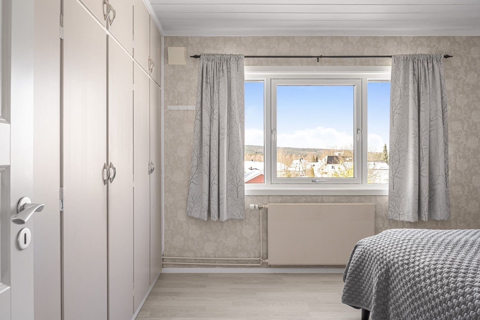 Soverommet har laminat på gulv, tapet på veggene og et stort vindu som slipper inn fint lys. Galleribilde