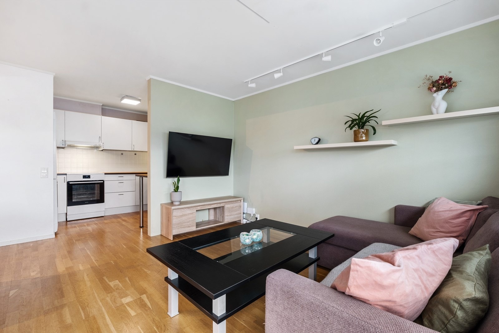 Den åpne løsningen mellom stue og kjøkken skaper et sosialt og lyst allrom Galleribilde