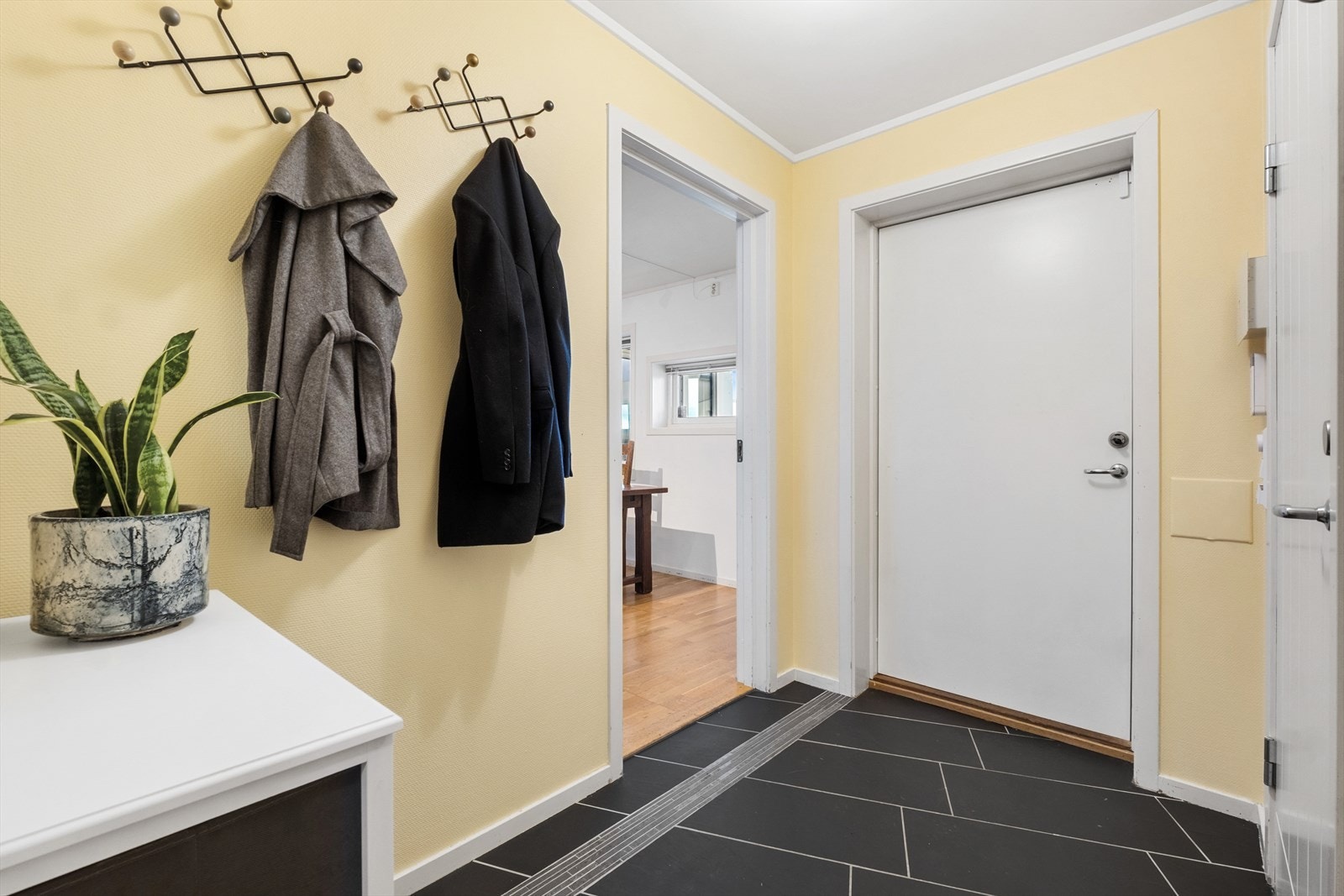 Velkommen inn i en praktisk entré med flislagt gulv og plass til yttertøy. Galleribilde