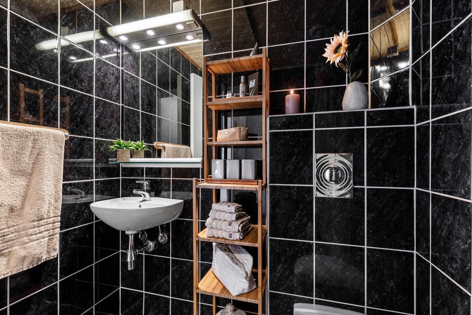 Badet er utstyrt med vegghengt toalett og servant med speil over. Galleribilde