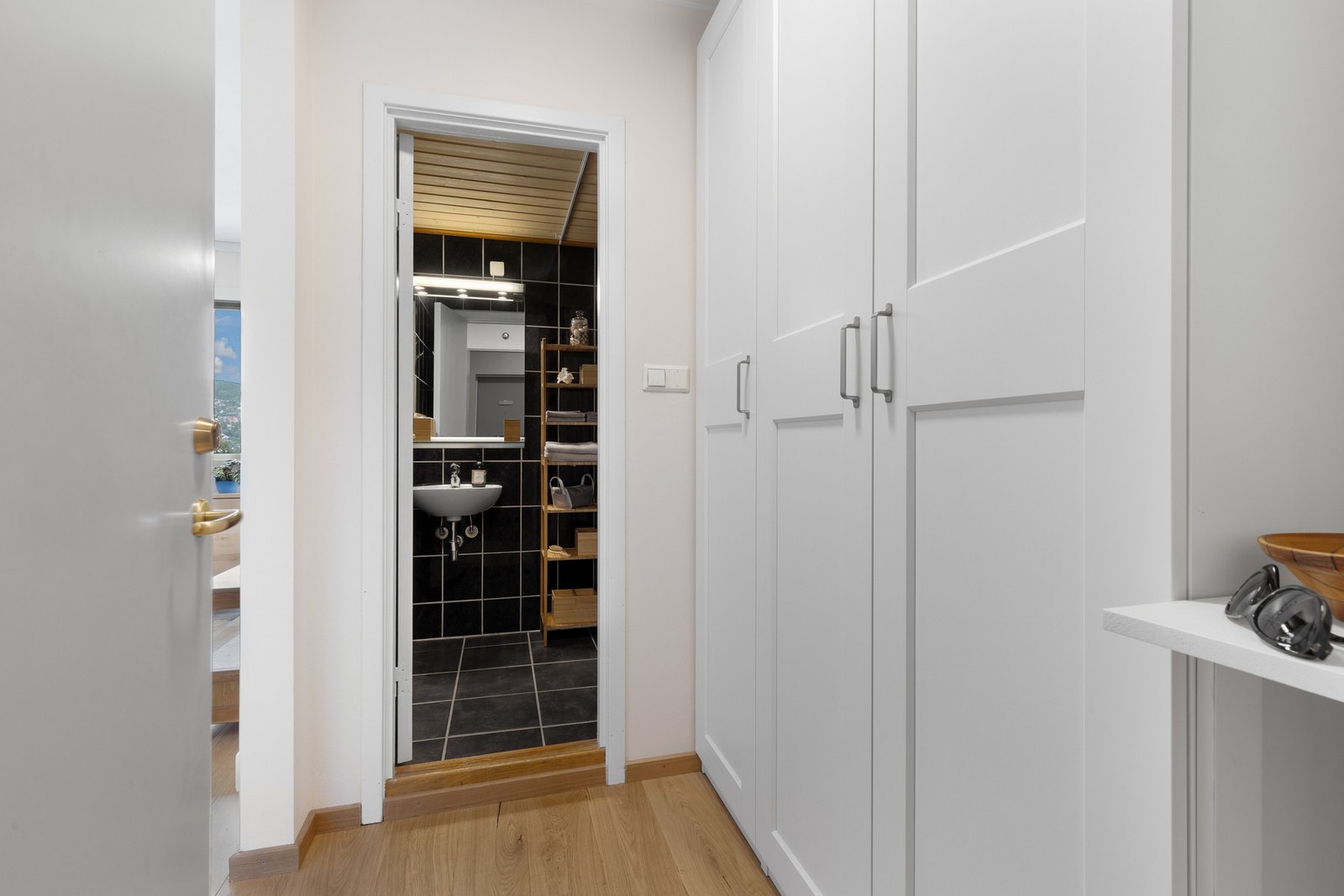 Langs den ene veggen i entreen er det garderobeskap med hvite rammefronter. Galleribilde