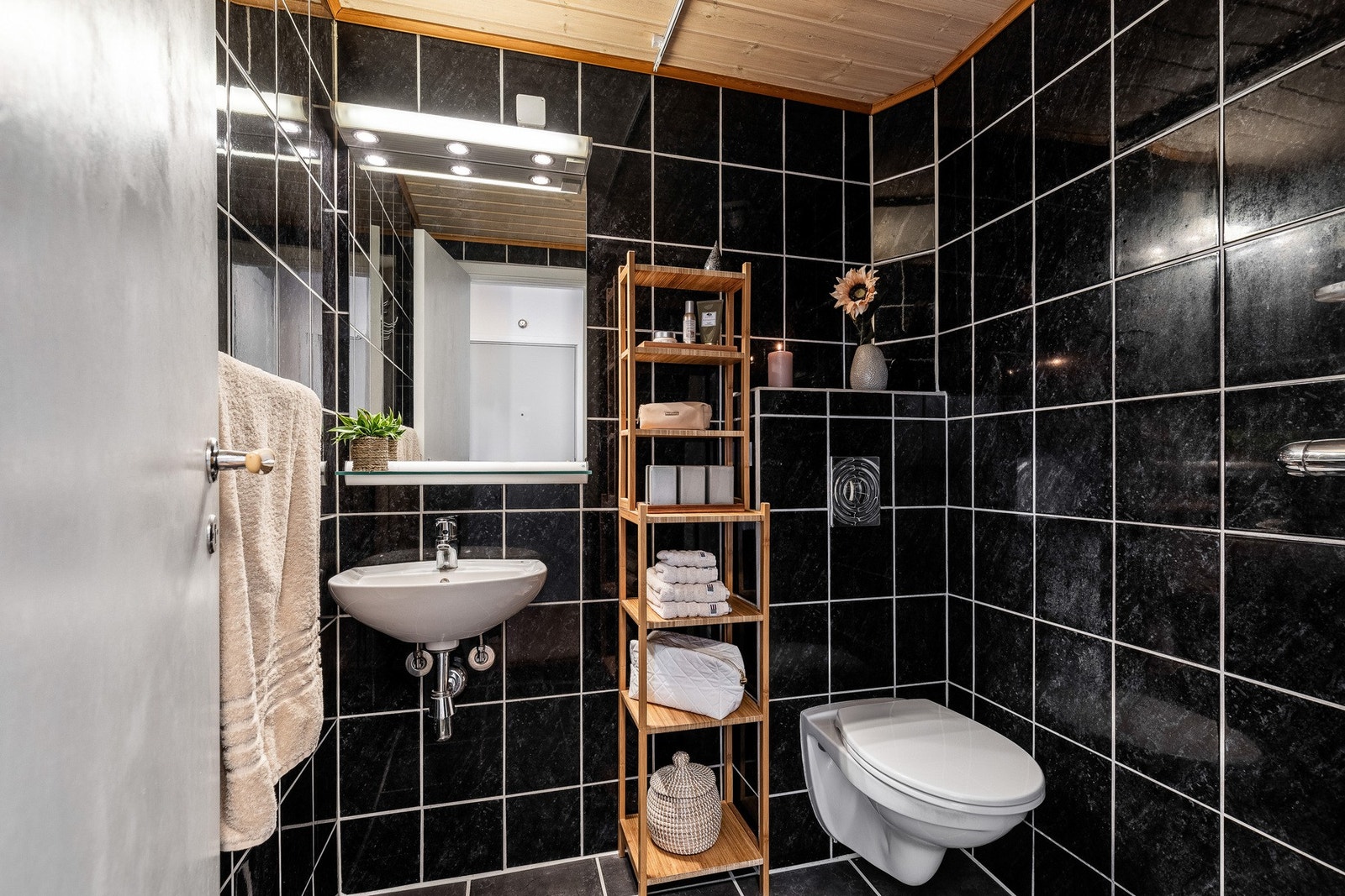 Leiligheten har et mindre, men godt utnyttet bad med mørke, flislagte overfalter. Galleribilde
