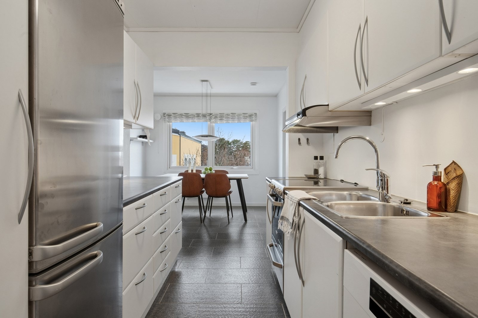 Kjøkkenet er ellers utstyrt med frittstående kjøleskap, oppvaskmaskin, komfyr og kjøkkenventilator med avtrekk ut. Galleribilde