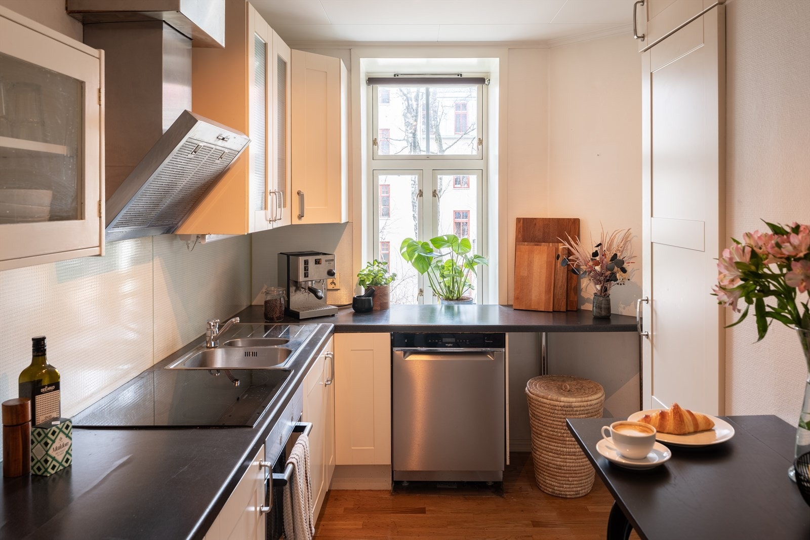 Innholdsrikt kjøkken med plass til frokostbord og utsikt ut mot hagen. Galleribilde