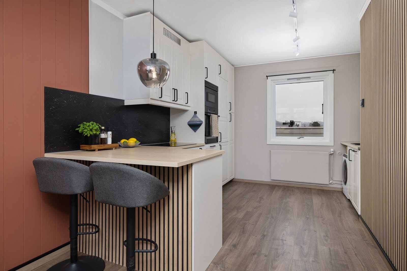 Kjøkkeninnredningen fra 2025 har profilerte fronter, laminatbenkeplate og integrert stekeovn og platetopp. Galleribilde