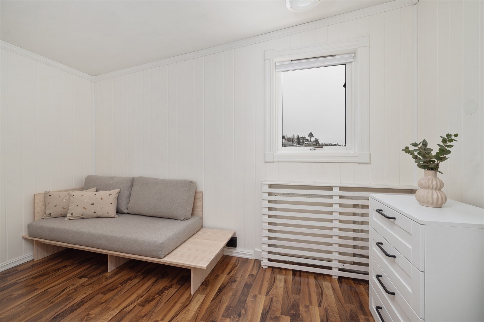 Rommet har malte panelplater på veggene og laminat på gulvet. Galleribilde