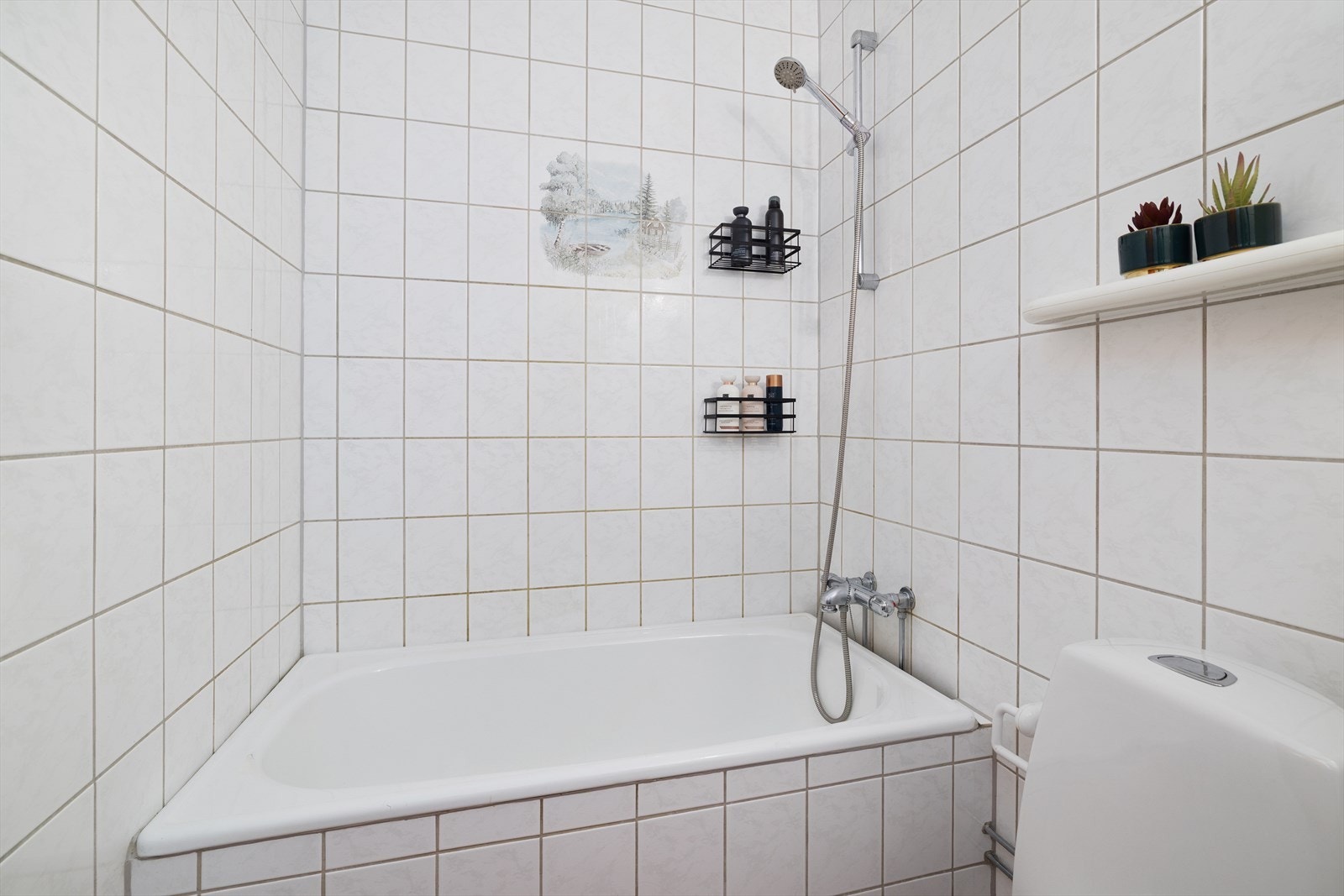 Badet er innredet med et praktisk, innfliset badekar med dusjmulighet. Galleribilde