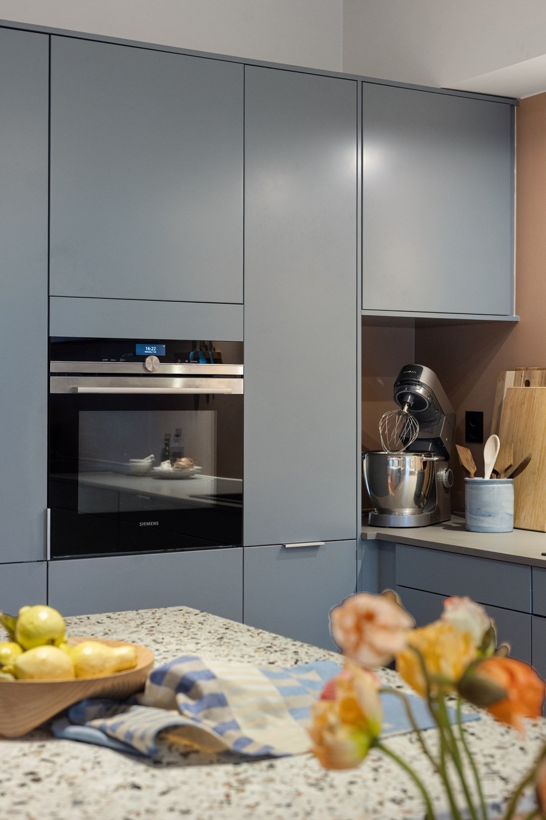 Høyskap med integrert stekeovn i praktisk arbeidshøyde og egen plass til kjøkkenmaskinen gjør det praktisk ved kokkelering. Galleribilde