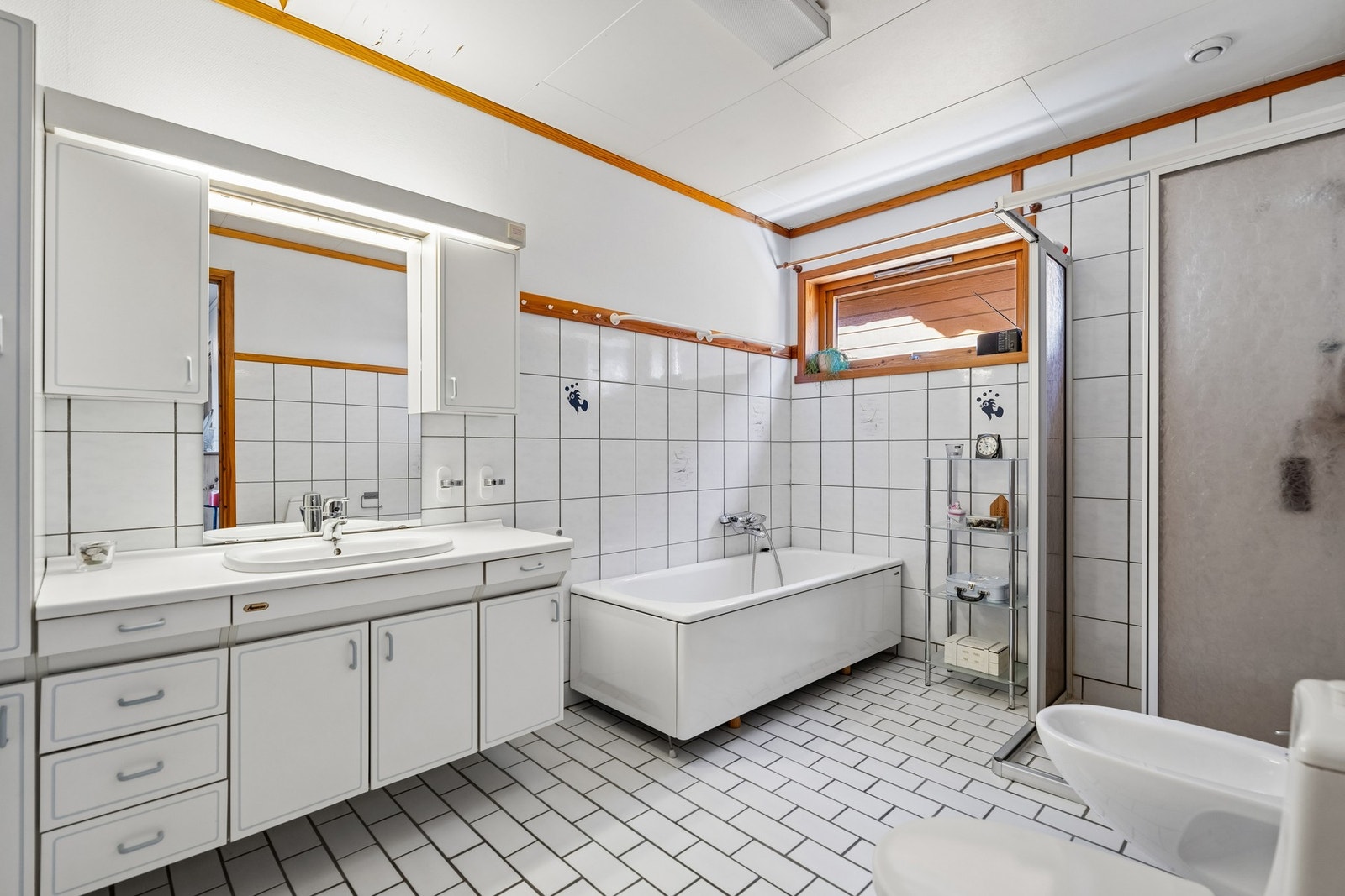 Badet har flislagt gulv og vegger samt baderomsinnredning med servant og oppbevaring. Galleribilde