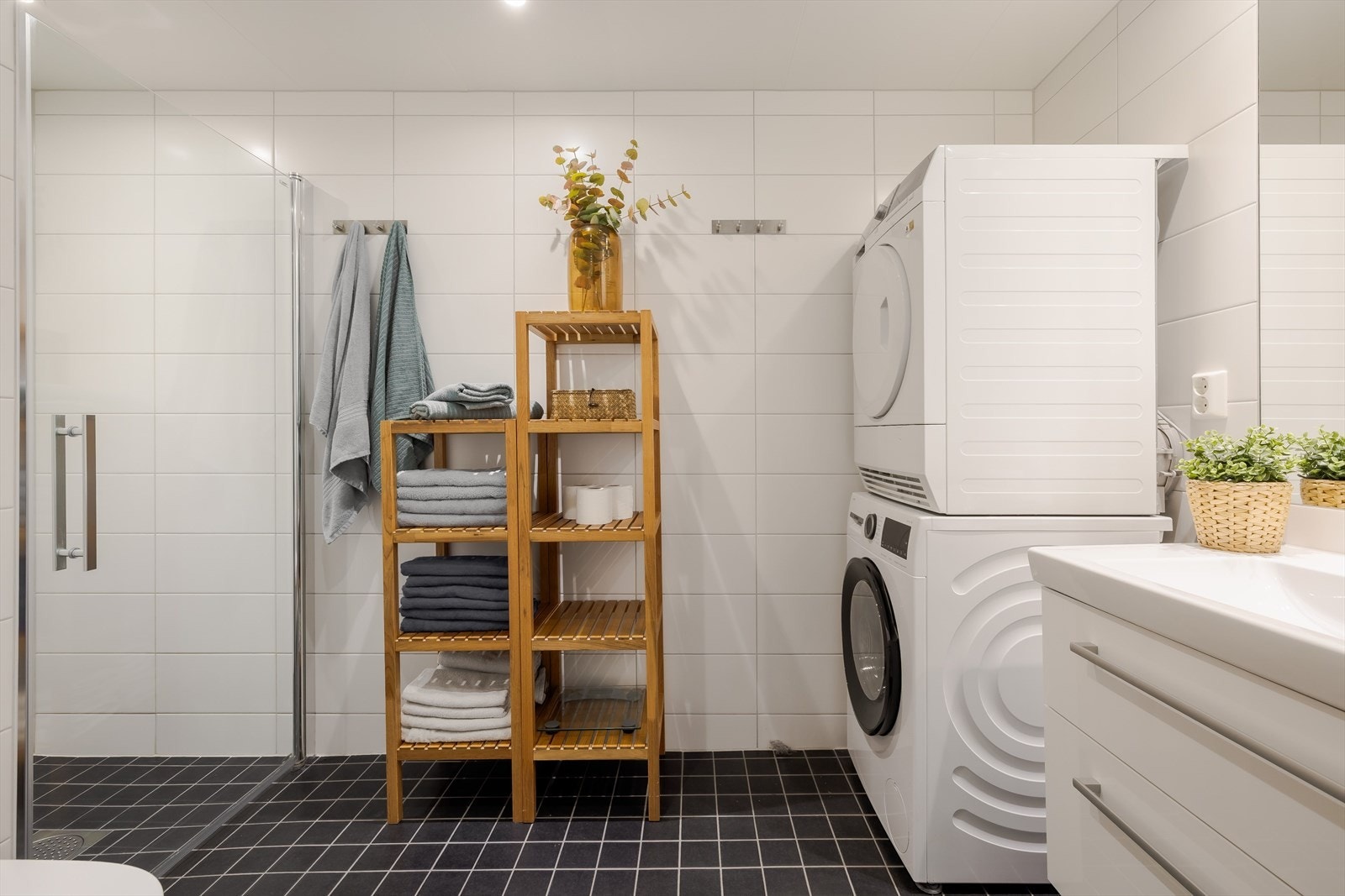 Lyst, flislafgt bad med varme i gulvet. I himlingen er det downlights som sørger for god belysning. Rommet er utstyrt med veggmontert toalett og har opplegg for vaskemaskin. Galleribilde