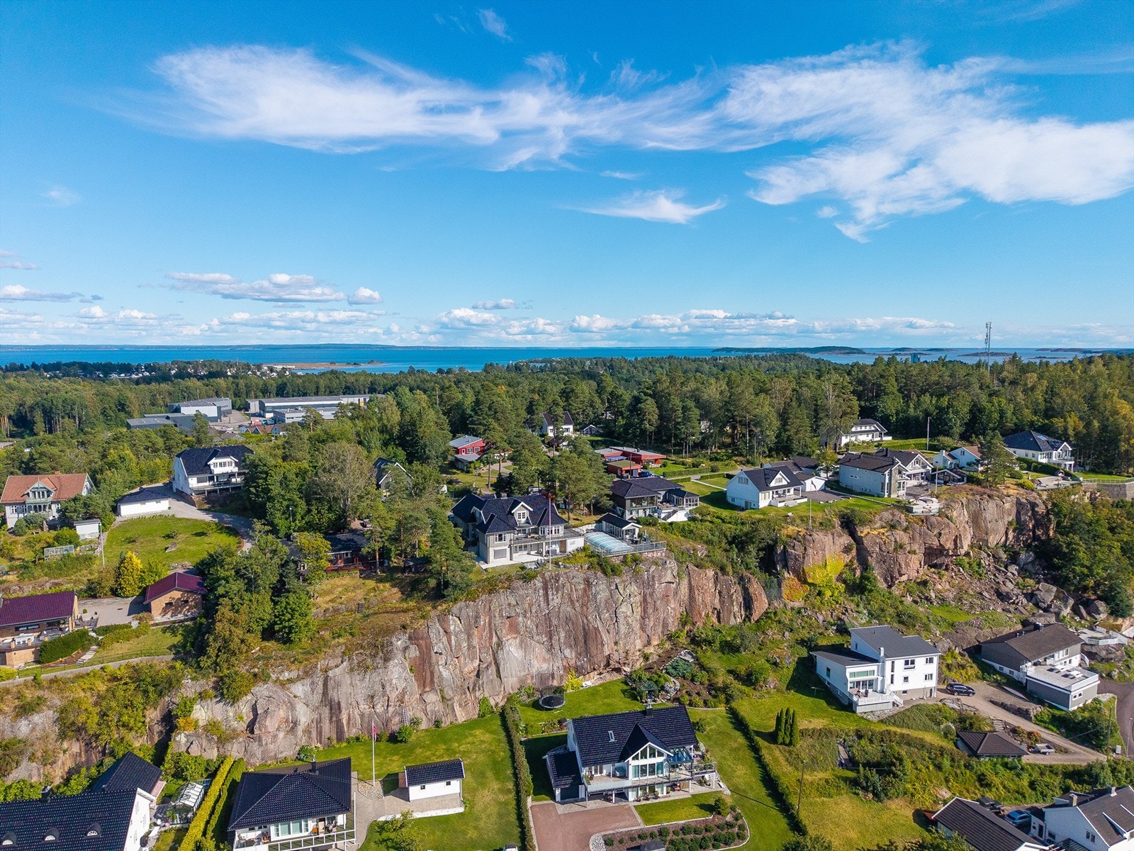Tomten er omgitt av trær som skaper både skjerming og en naturlig ramme rundt eiendommen. Galleribilde