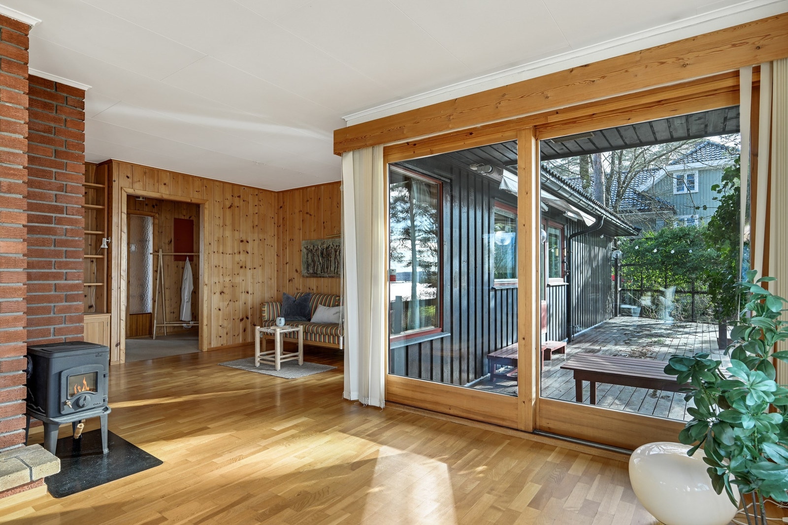 Skyvedører som åpner opp mot en hyggelig terrasse. De store vindusflatene slipper inn rikelig med dagslys og skaper en fin overgang mellom inne- og uteareal. Galleribilde