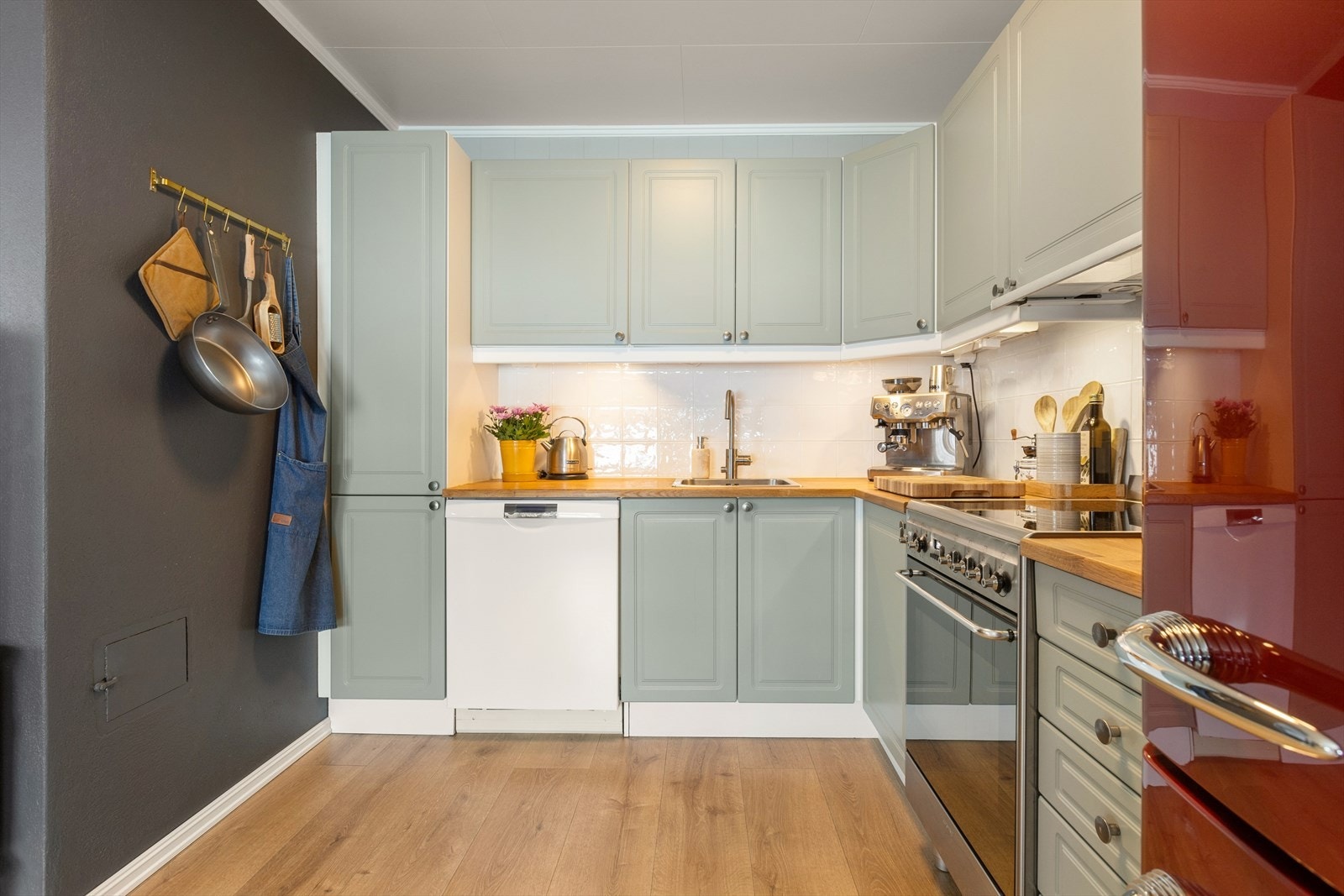 Elegant kjøkken med friske farger som har rikelig med skap og benkeplass. Galleribilde