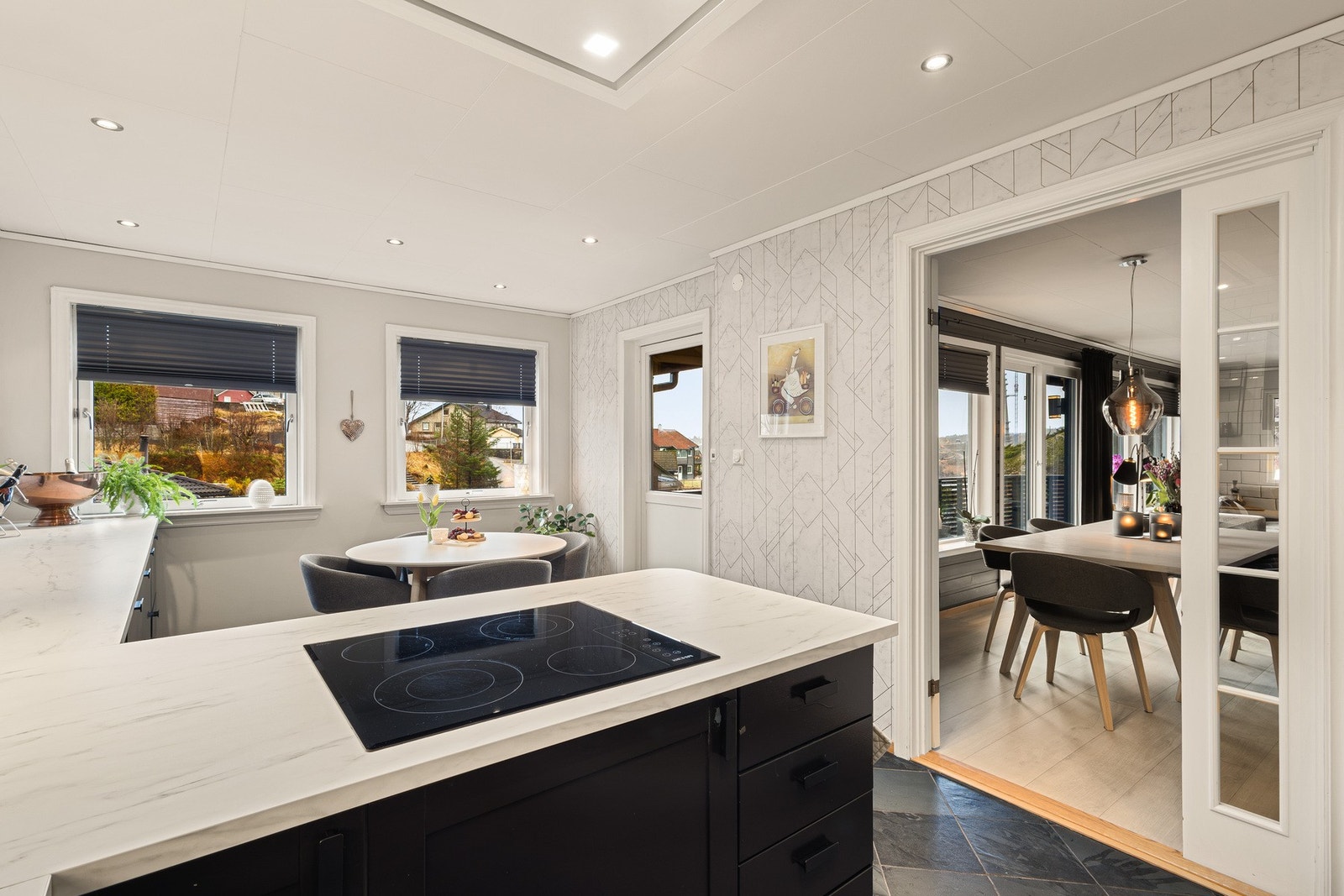 Kjøkkeninnredningen har et moderne preg og består av slette fronter, laminat benkeplate, over benkeplaten er det benyttet fliser, oppvaskkum og ventilator. Galleribilde