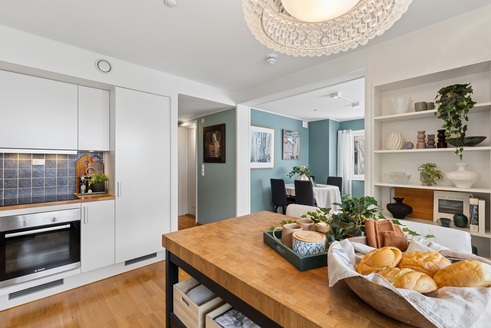 Det moderne kjøkkenet fremstår som både stilrent og funksjonelt, med glatte fronter og benkeplate i heltre som gir rommet et varmt og eksklusivt preg. Galleribilde