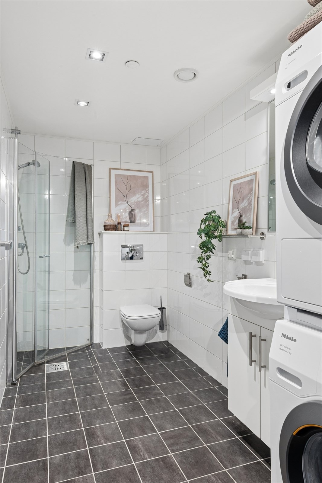 Badet er flislagt og har varmekabler i gulvet, dusjhjørne og opplegg for vaskemaskin. Galleribilde