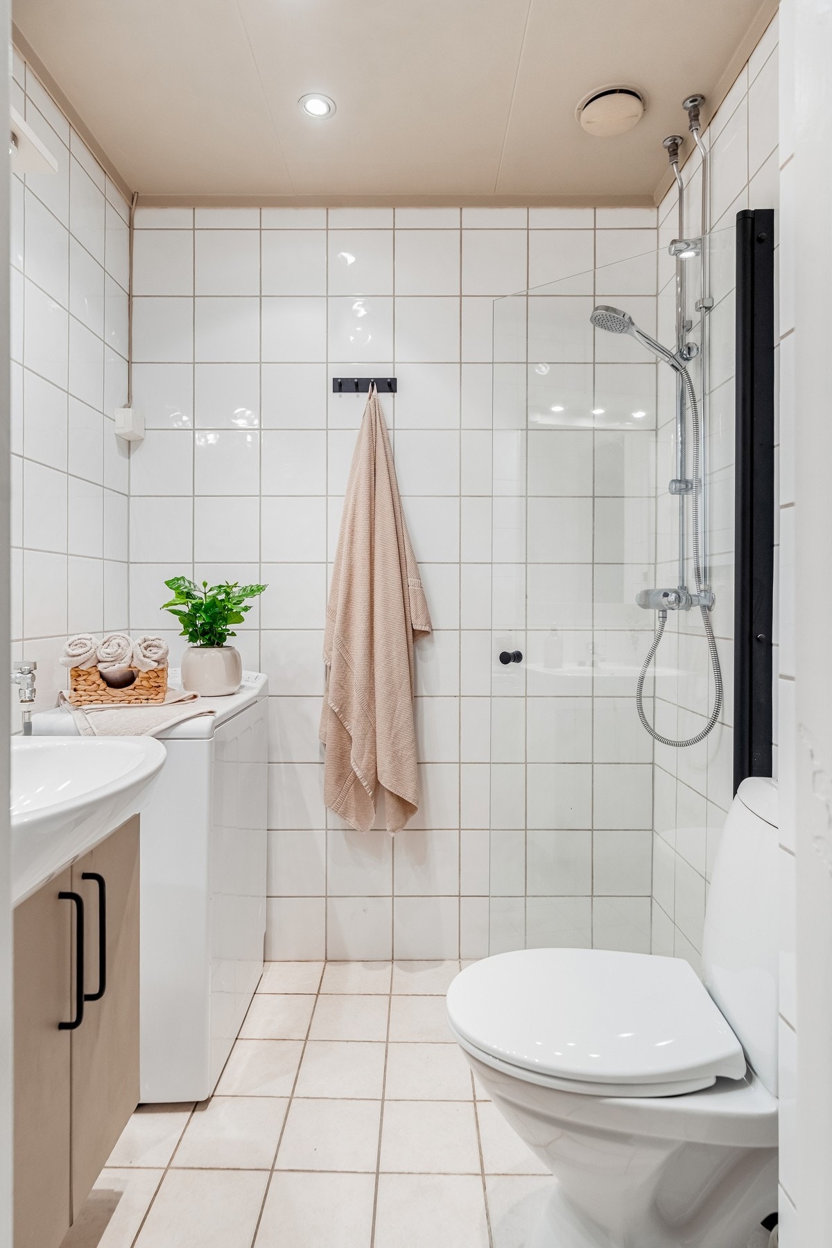 Badet er utstyrt med vegghengt toalett, servant, dusjhjørne samt opplegg for vaskemaskin. Naturlig ventilasjon. Galleribilde