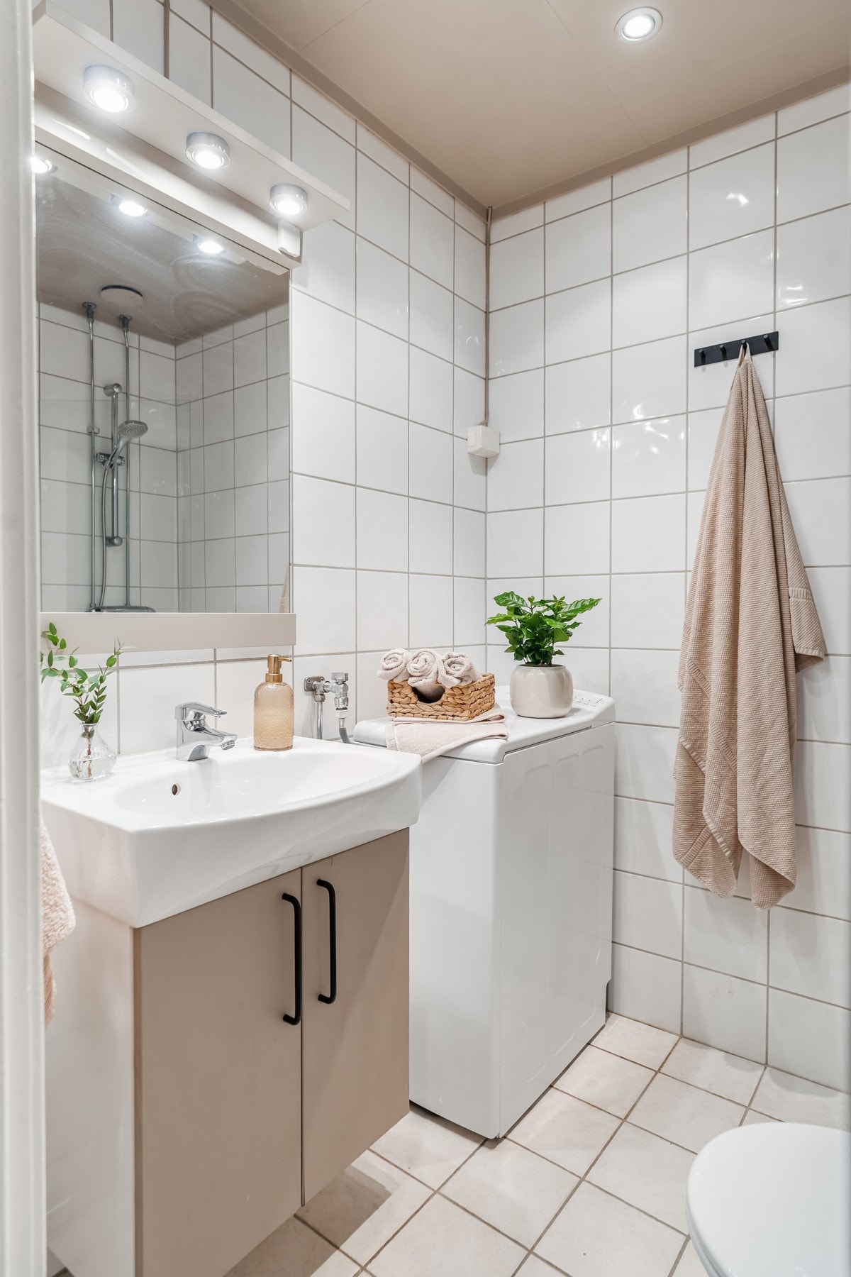 Pent baderom fra 2004. Baderomsinnredningen har skap med glatte fronter og speil over servant med belysning. Galleribilde