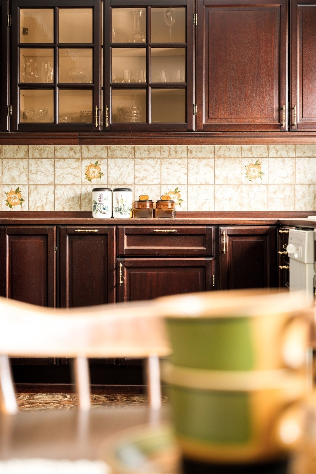 De retroinspirerte flisene, dekorert med blomster i varme gule og myke grønne toner, bringer en leken og sjarmerende energi inn i kjøkkenet. Galleribilde