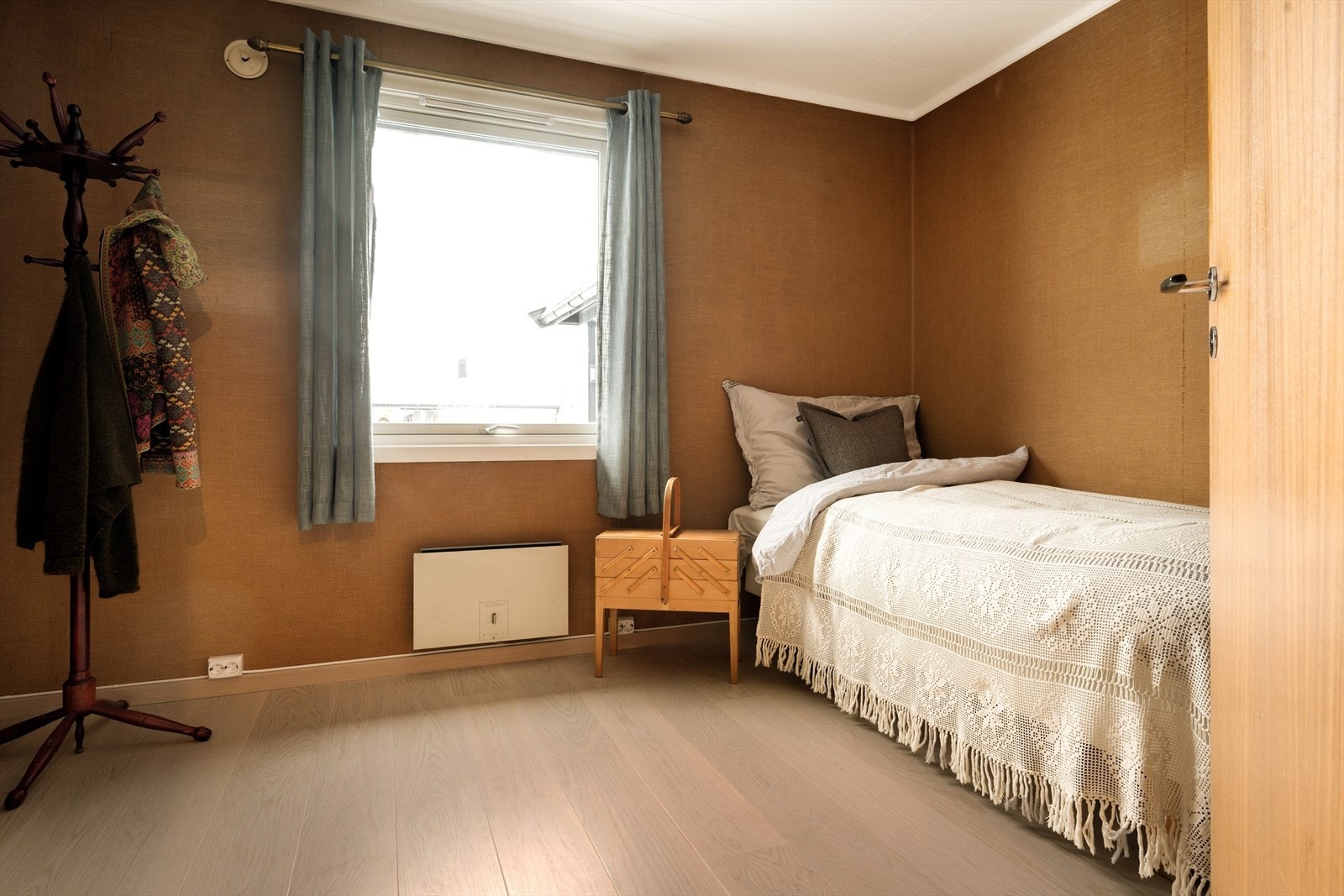 Soverom 3 tar deg rett tilbake til 1970-tallet - på den aller beste måten. Veggene er kledd i mørk, nesten sennepsgul strietapet som gir rommet en dyp og lun karakter. Galleribilde