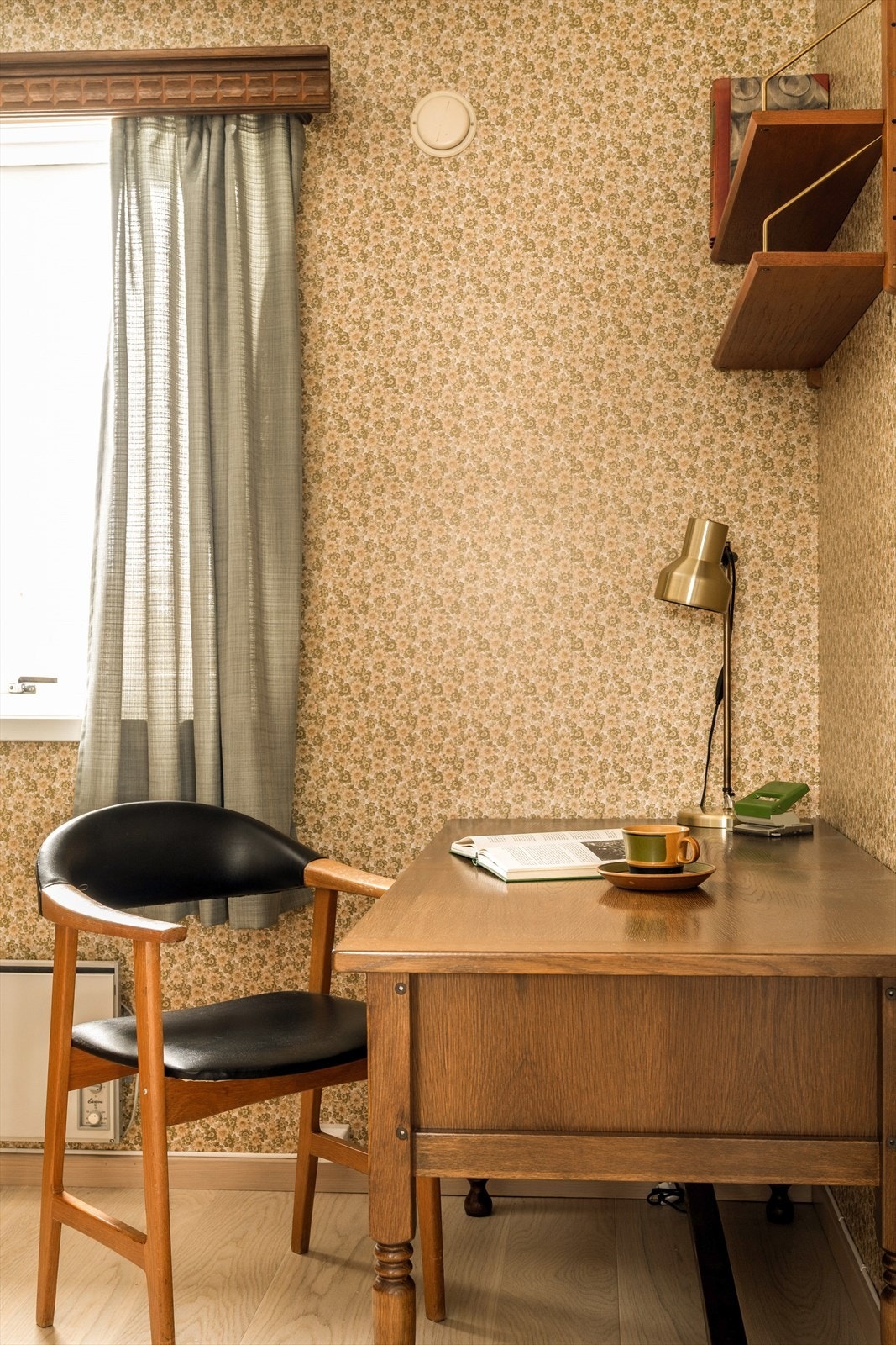 Fra spisestuen ledes du videre inn i boligens eget lille tidskapsel - kontoret. Her møter du blomstrete 1970 talls tapet som stolt brer seg over veggene, fullt av farger, former og den karakteristiske optimismen fra tiåret. Galleribilde