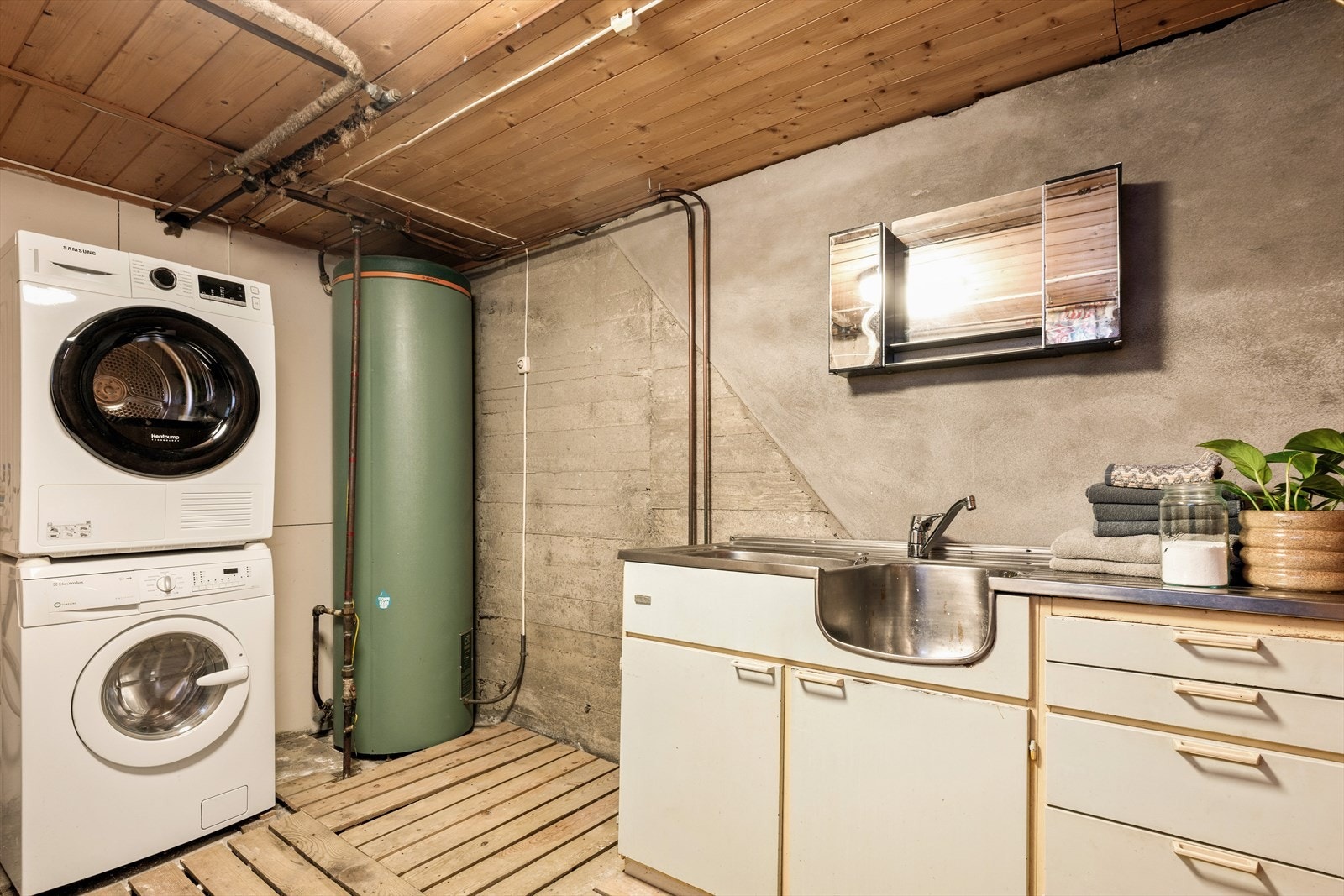 Betonggulvet er smart belagt med trepaller, som både luner og gir et mer behagelig underlag. Stråleovnen gir gode tørkemuligheter - et rom som er tilrettelagt for effektiv hverdagshåndtering, enten det gjelder klesvask eller våte ytterklær. Galleribilde