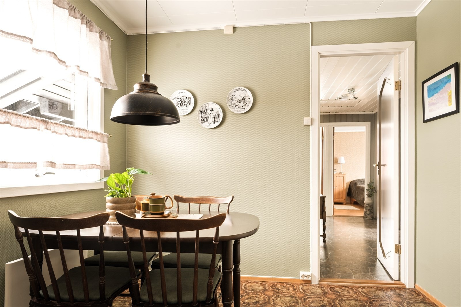 Under kjøkkenvinduet, badet i naturlig dagslys, står det koselige kjøkkenbordet - en selvsagt samlingsplass i rommet. Galleribilde