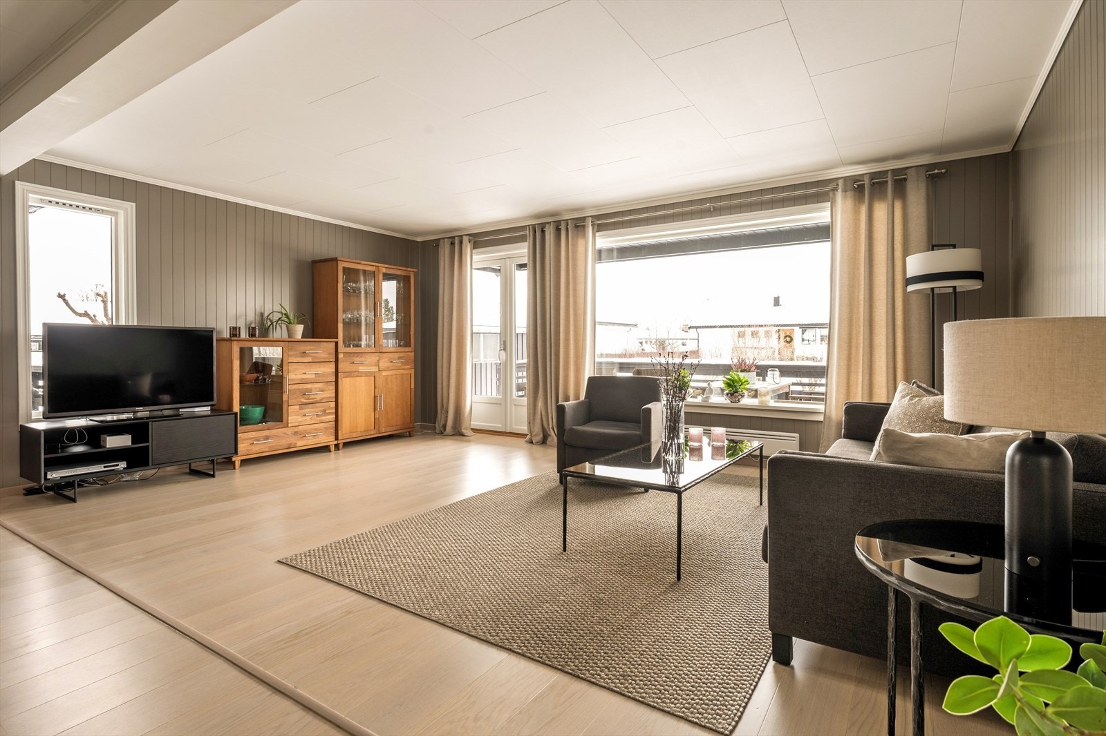 De store stuevinduene slipper inn rikelig med naturlig lys og gir rommet en åpen og levende karakter gjennom hele dagen. Her strømmer solen inn og fremhever de lyse flatene, samtidig som utsynet gir en fin kontakt med uteområdet. Galleribilde