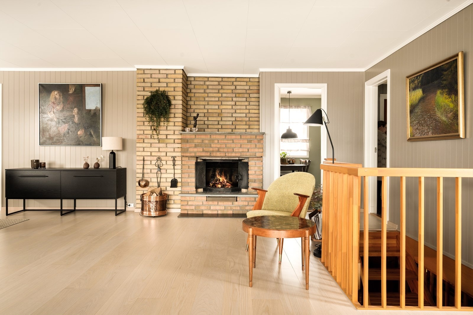 Peisen, med sine tette støpejernsdører, tilfører en ekstra dimensjon av autentisk retro. Her er det ikke flammene som spiller hovedrollen visuelt - men selve formen, materialet og den solide tilstedeværelsen. Galleribilde