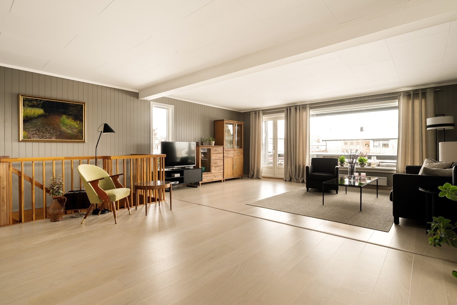 Fra stuen er det direkte utgang til en overbygget veranda - en naturlig forlengelse av oppholdsrommet. Her kan du flytte sofakroken ut på varme dager, nyte morgenkaffen i ly for vær og vind, eller samle familie og venner til sene sommerkvelder. Galleribilde