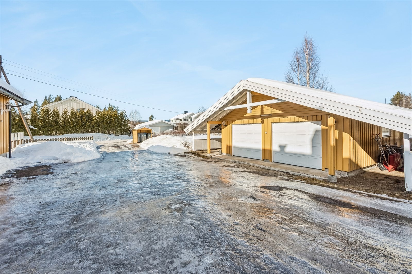 Eiendommen har en stor dobbelgarasje med boder, totalt 59 m² (BRA-e). I tillegg er det carportløsninger på hver side. Galleribilde