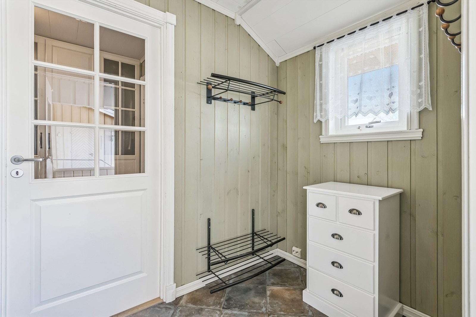 Vindfanget er en del av tilbygget fra 1986 og har fliser på gulv med gulvvarme. Galleribilde